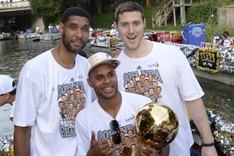 SAN ANTONIO, TX - JUNE 18:  Tim Duncan, Patty Mills, and Aron Baynes of the San Antonio Spurs pose for photos during The San Antonio Spurs NBA Championship Celebration Parade on June 18, 2014 on the San Antonio River in San Antonio, Texas. NOTE TO USER: U