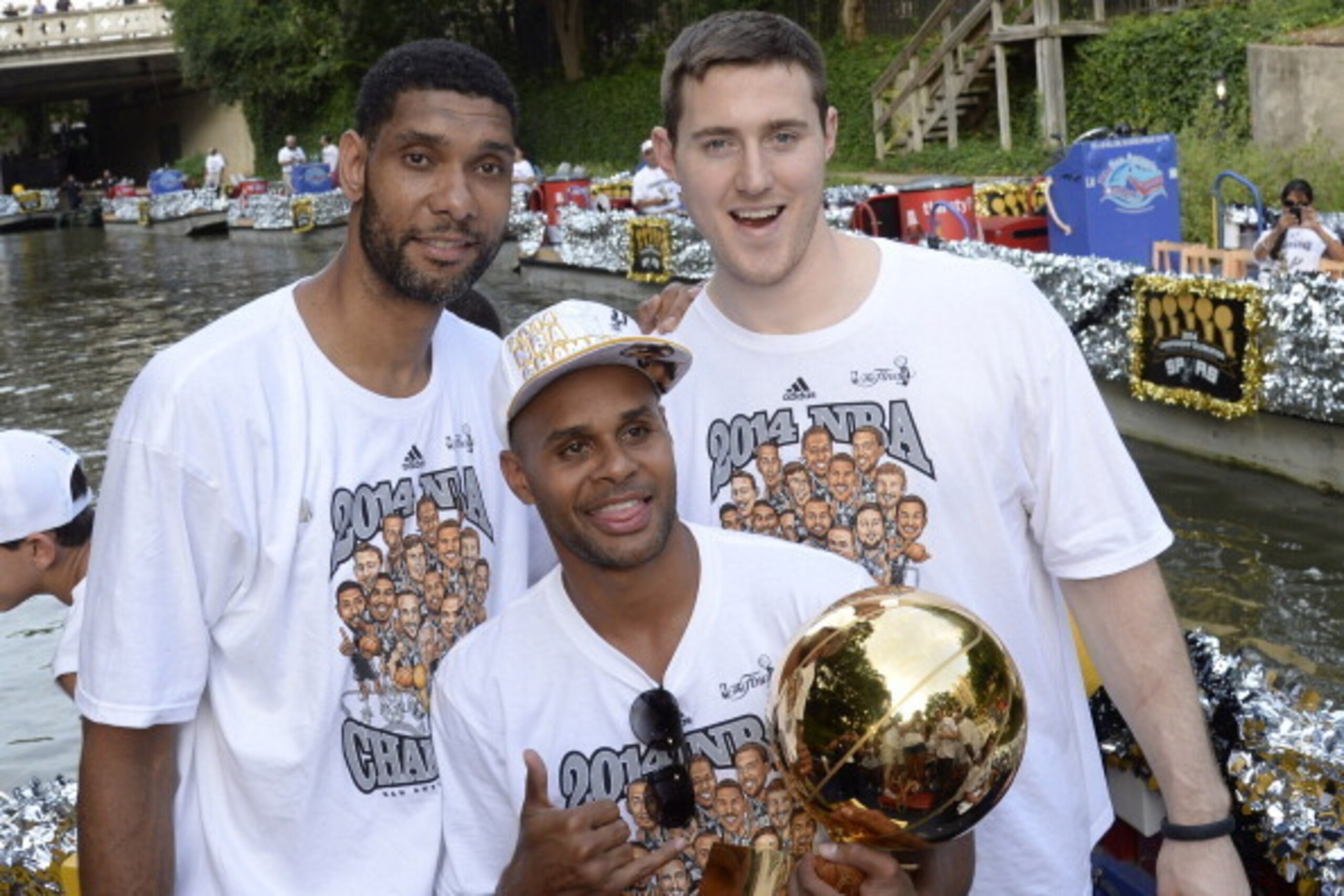 SAN ANTONIO, TX - JUNE 18:  Tim Duncan, Patty Mills, and Aron Baynes of the San Antonio Spurs pose for photos during The San Antonio Spurs NBA Championship Celebration Parade on June 18, 2014 on the San Antonio River in San Antonio, Texas. NOTE TO USER: U