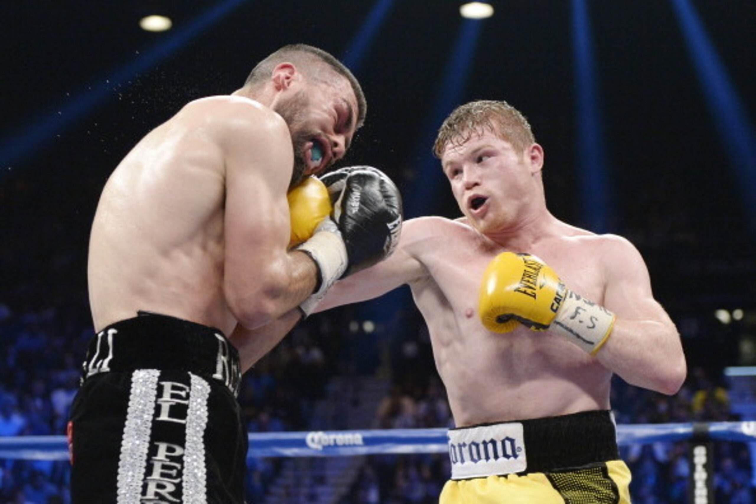 LAS VEGAS, NV - MARCH 8: Canelo Alvarez throws a punch against Alfredo Angulo (L) during the non-title, 12-round super welterweight bout at the MGM Grand Garden March 8, 2014, in Las Vegas, Nevada. Alvarez won by technical knock out after the referee stop