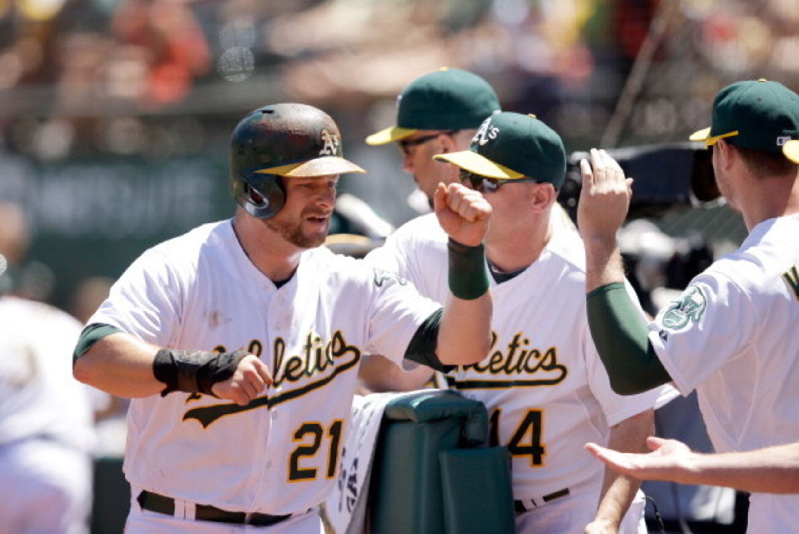OAKLAND, CA - JULY 06:  Stephen Vogt #21 of the Oakland Athletics is congratulated by teammates after he scored on a hit by Nate Freiman #35 in the fourth inning of their game against the Toronto Blue Jays at O.co Coliseum on July 6, 2014 in Oakland, Cali