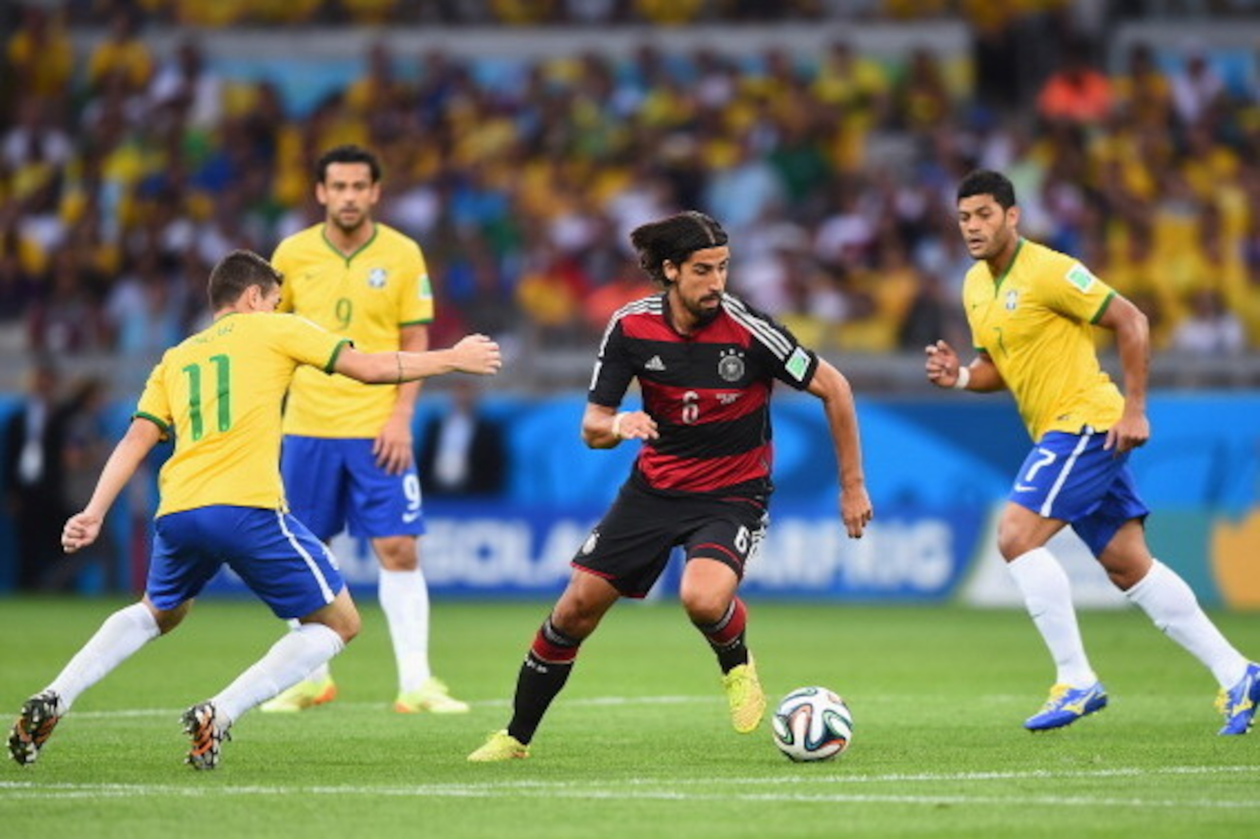 BELO HORIZONTE, BRAZIL - JULY 08:  Sami Khedira (C) of Germany runs past Oscar (L) of Brazil with the ball during the 2014 FIFA World Cup Brazil Semi Final match between Brazil and Germany at Estadio Mineirao on July 8, 2014 in Belo Horizonte, Brazil.  (P