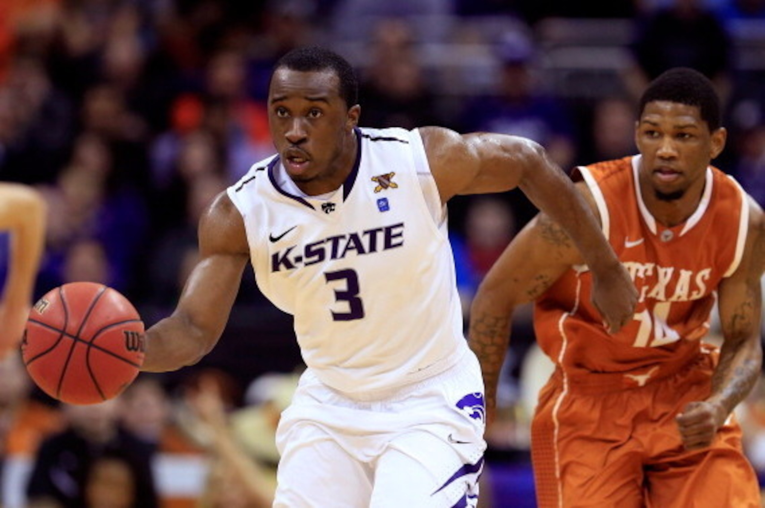 KANSAS CITY, MO - MARCH 14: Martavious Irving #3 of the Kansas State Wildcats dribbles away from Jonathan Holmes #10 of the Texas Longhorns in the second half during the Quarterfinals of the Big 12 basketball tournament at Sprint Center on March 14, 2013 