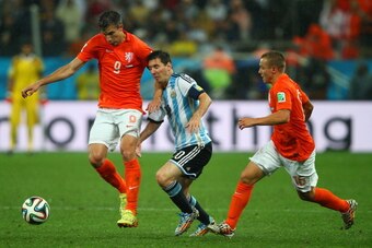 SAO PAULO, BRAZIL - JULY 09: Robin van Persie of the Netherlands challenges Lionel Messi of Argentina during the 2014 FIFA World Cup Brazil Semi Final match between the Netherlands and Argentina at Arena de Sao Paulo on July 9, 2014 in Sao Paulo, Brazil. 