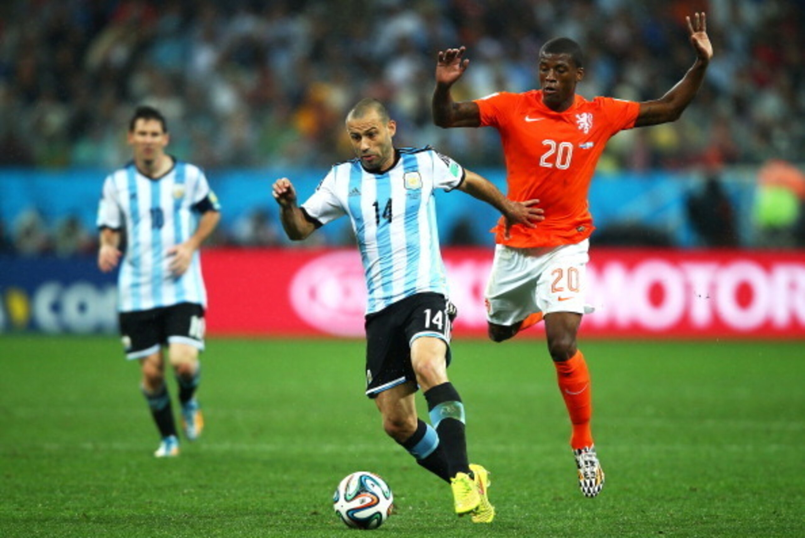 SAO PAULO, BRAZIL - JULY 09:  Javier Mascherano of Argentina controls the ball as Georginio Wijnaldum of the Netherlands gives chase during the 2014 FIFA World Cup Brazil Semi Final match between the Netherlands and Argentina at Arena de Sao Paulo on July