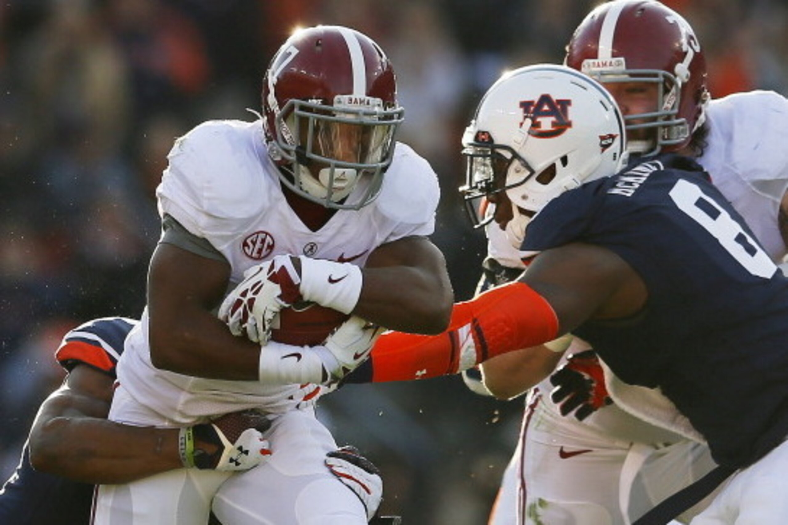 AUBURN, AL - NOVEMBER 30:  Kenyan Drake #17 of the Alabama Crimson Tide runs the ball in the second quarter against Jermaine Whitehead and Cassanova McKinzy #8 of the Auburn Tigers at Jordan-Hare Stadium on November 30, 2013 in Auburn, Alabama.  (Photo by