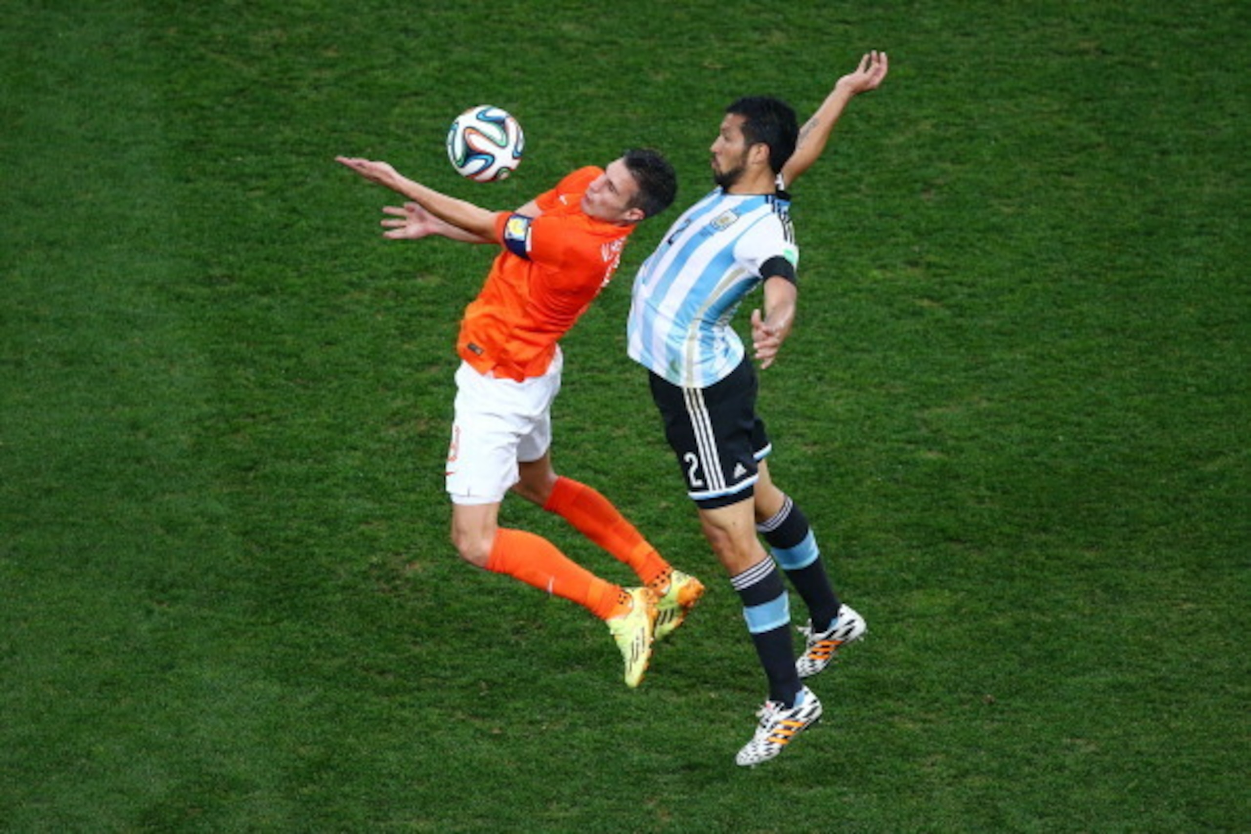 SAO PAULO, BRAZIL - JULY 09:  Robin van Persie of the Netherlands and Ezequiel Garay of Argentina compete for the ball during the 2014 FIFA World Cup Brazil Semi Final match between the Netherlands and Argentina at Arena de Sao Paulo on July 9, 2014 in Sa