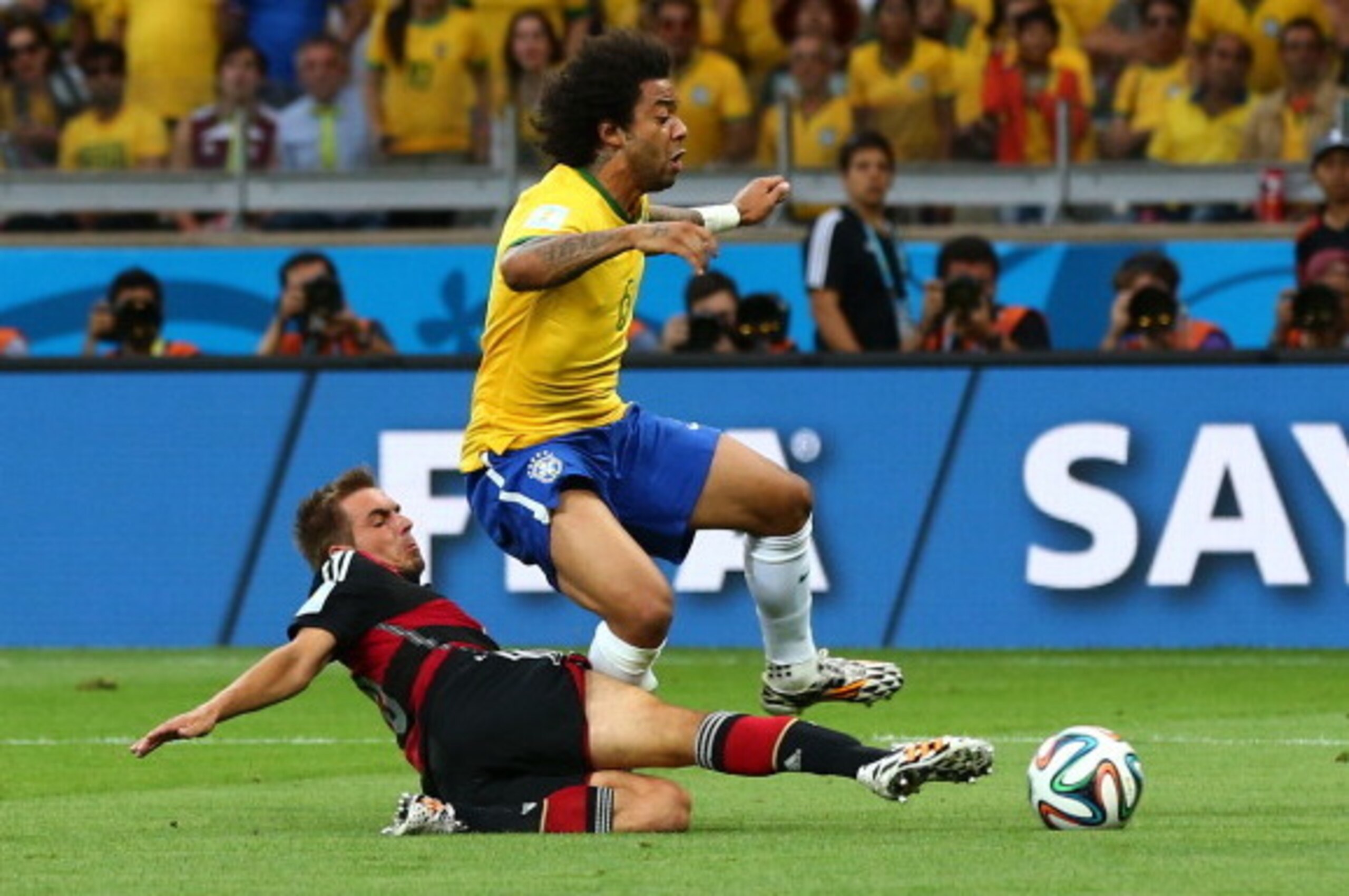 BELO HORIZONTE, BRAZIL - JULY 08:  Philipp Lahm of Germany tackles Marcelo of Brazil during the 2014 FIFA World Cup Brazil Semi Final match between Brazil and Germany at Estadio Mineirao on July 8, 2014 in Belo Horizonte, Brazil.  (Photo by Martin Rose/Ge
