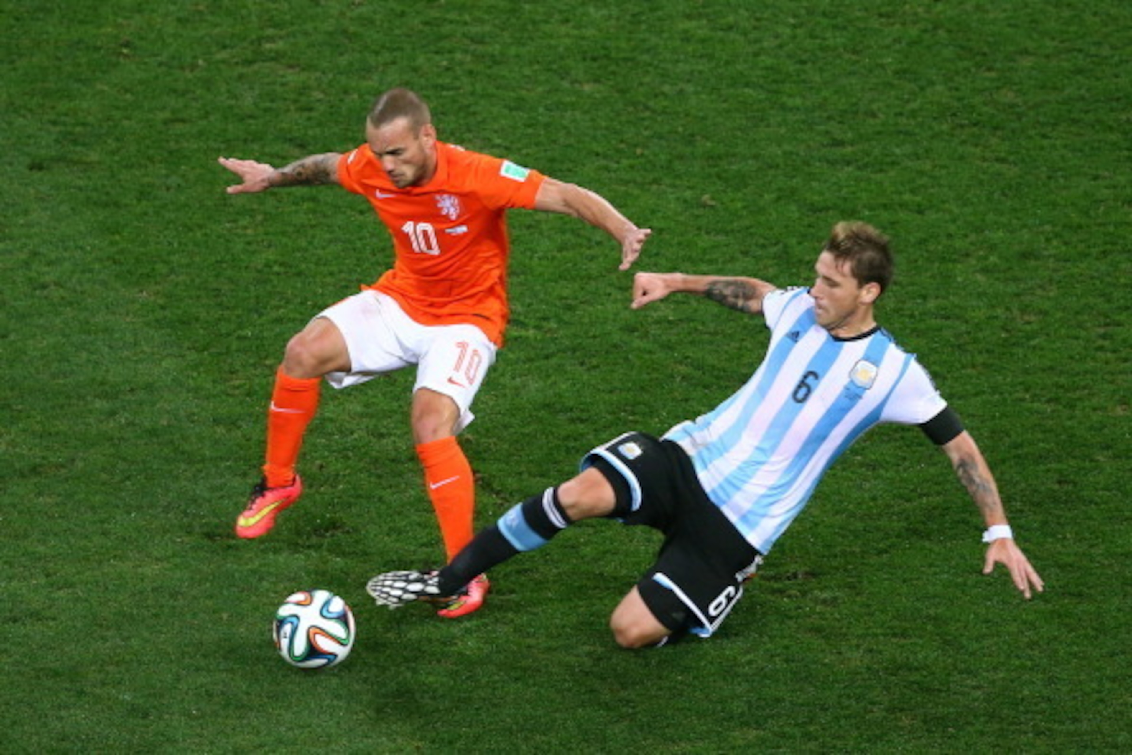 SAO PAULO, BRAZIL - JULY 09:  Lucas Biglia of Argentina tackles Wesley Sneijder of the Netherlands during the 2014 FIFA World Cup Brazil Semi Final match between the Netherlands and Argentina at Arena de Sao Paulo on July 9, 2014 in Sao Paulo, Brazil.  (P