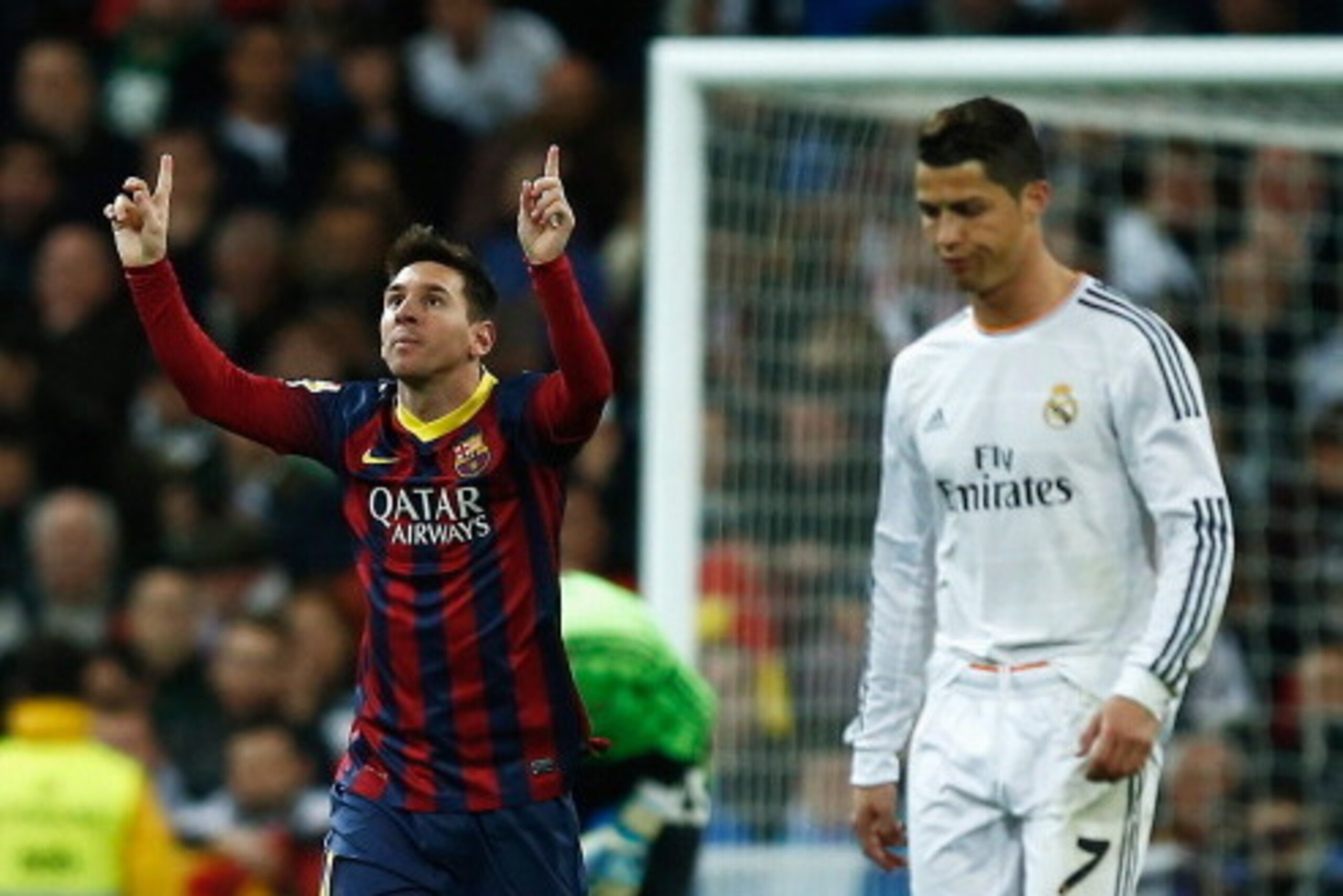 MADRID, SPAIN - MARCH 23:  Lionel Messi of Barcelona celebrates scoring his team's third goal as Cristiano Ronaldo of Real Madrid looks dejected during the La Liga match between Real Madrid CF and FC Barcelona at the Bernabeu on March 23, 2014 in Madrid, 
