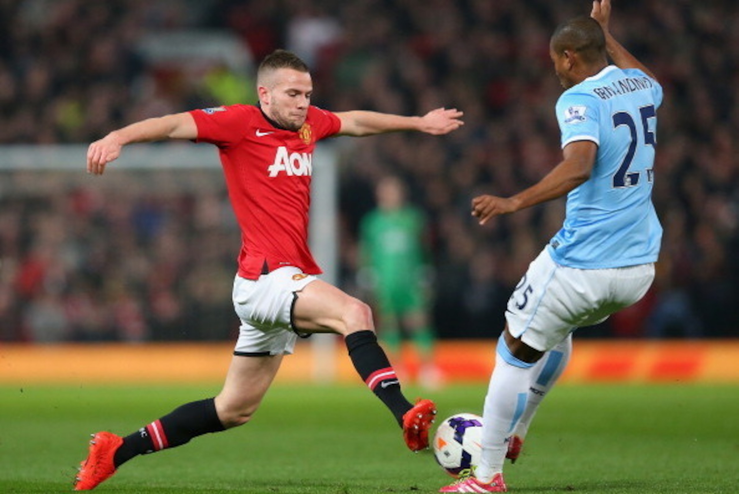 MANCHESTER, ENGLAND - MARCH 25:  Tom Cleverley of Manchester United competes with Fernandinho of Manchester City during the Barclays Premier League match between Manchester United and Manchester City at Old Trafford on March 25, 2014 in Manchester, Englan