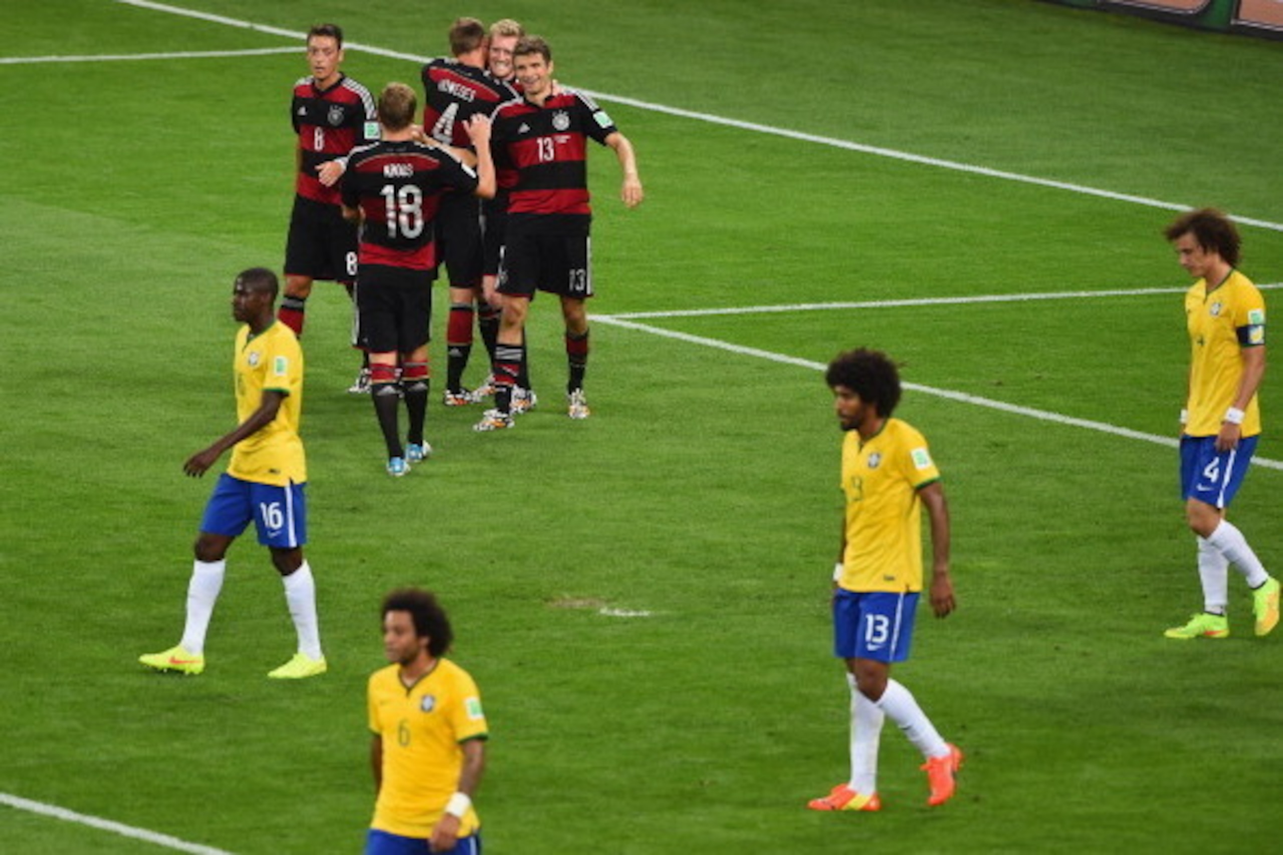 BELO HORIZONTE, BRAZIL - JULY 08: Andre Schuerrle of Germany celebrates scoring his team's sixth goal with teammates Mesut Oezil, Toni Kroos, Benedikt Hoewedes and Thomas Mueller as dejected Brazil players look on during the 2014 FIFA World Cup Brazil Sem