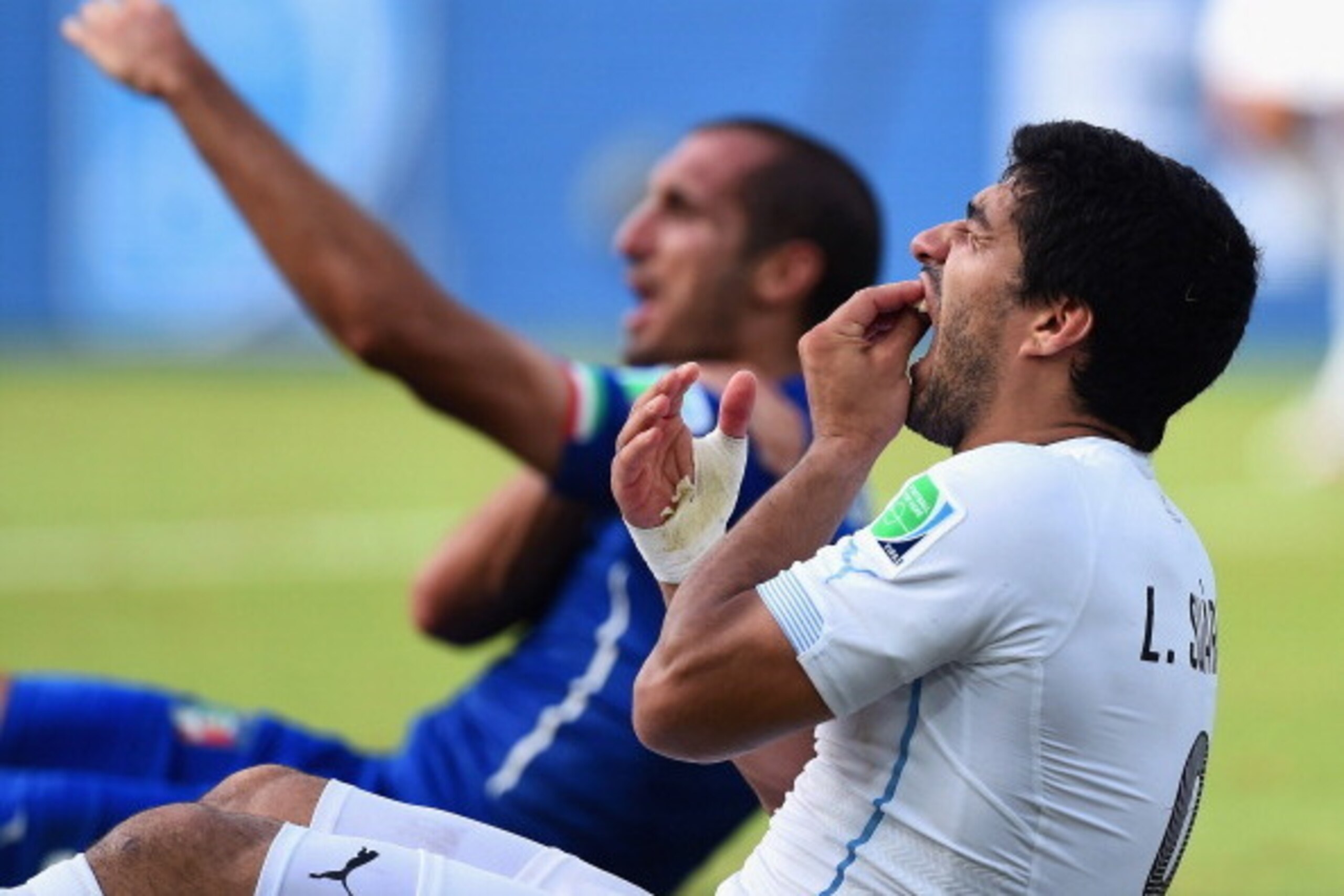 NATAL, BRAZIL - JUNE 24:  Luis Suarez of Uruguay and Giorgio Chiellini of Italy react after a clash during the 2014 FIFA World Cup Brazil Group D match between Italy and Uruguay at Estadio das Dunas on June 24, 2014 in Natal, Brazil.  (Photo by Matthias H