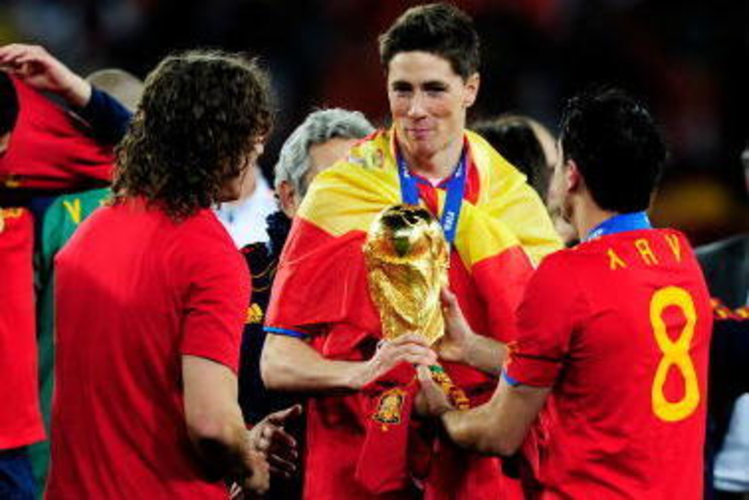 JOHANNESBURG, SOUTH AFRICA - JULY 11:  Fernando Torres of Spain holds theWorld Cup as he  celebrates winning the trophy with team mates Carles Puyol (L) and Xavi Hernandez during the 2010 FIFA World Cup South Africa Final match between Netherlands and Spa