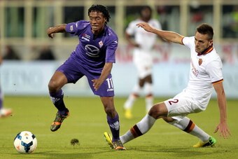 FLORENCE, ITALY - APRIL 19: Guillermo Cuadrado of ACF Fiorentina fights for the ball with Rafael Toloi of AS Roma during the Serie A match between ACF Fiorentina and AS Roma at Stadio Artemio Franchi on April 19, 2014 in Florence, Italy.  (Photo by Gabrie