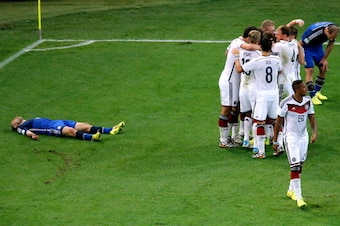 RIO DE JANEIRO, BRAZIL - JULY 13:  Mario Goetze of Germany celebrates scoring his team's first goal with teammates as a dejected Pablo Zabaleta (L) and Javier Mascherano of Argentina look on during the 2014 FIFA World Cup Brazil Final match between German