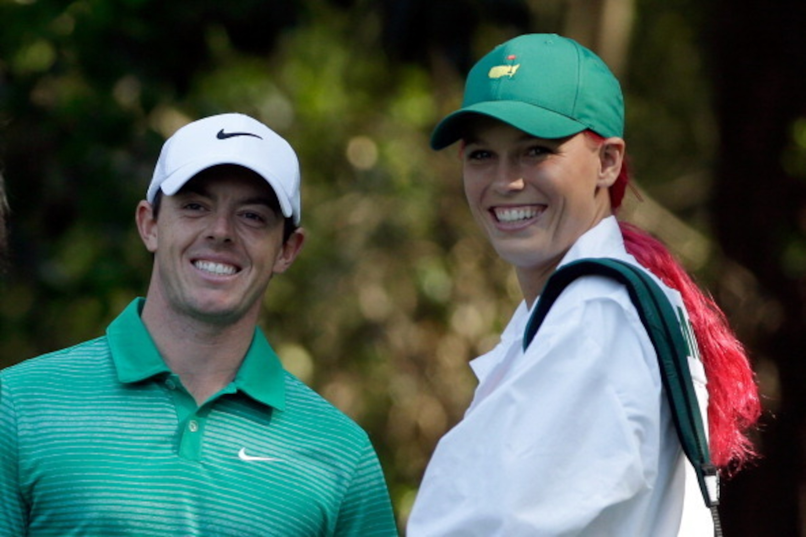 AUGUSTA, GA - APRIL 09:  Rory McIlroy of Northern Ireland alongside his caddie/girlfriend Caroline Wozniacki during the 2014 Par 3 Contest prior to the start of the 2014 Masters Tournament at Augusta National Golf Club on April 9, 2014 in Augusta, Georgia