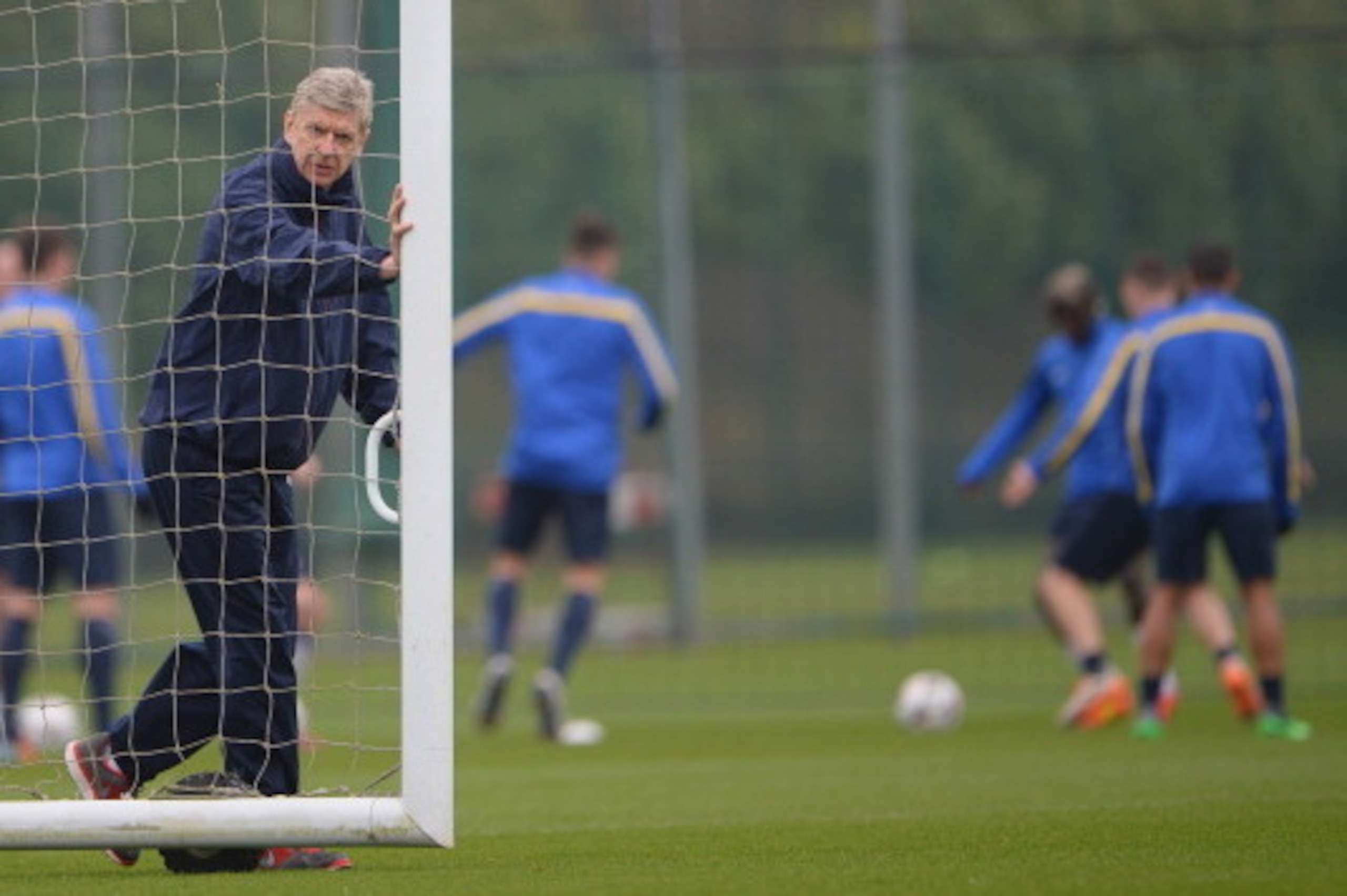 ST ALBANS, ENGLAND - MARCH 10:  Arsenal manager Arsene Wenger moves the goalposts during the Arsenal training session at London Colney on March 10, 2014 in St Albans, England.  (Photo by Michael Regan/Getty Images)