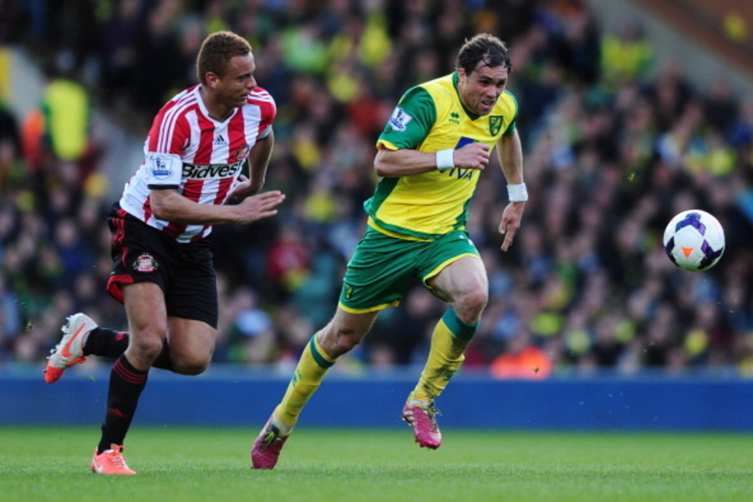 NORWICH, ENGLAND - MARCH 22:  Johan Elmander (R) of Norwich City and Wes Brown of Sunderland chase the ball during the Barclays Premier League match between Norwich City and Sunderland at Carrow Road on March 22, 2014 in Norwich, England. (Photo by Alex B
