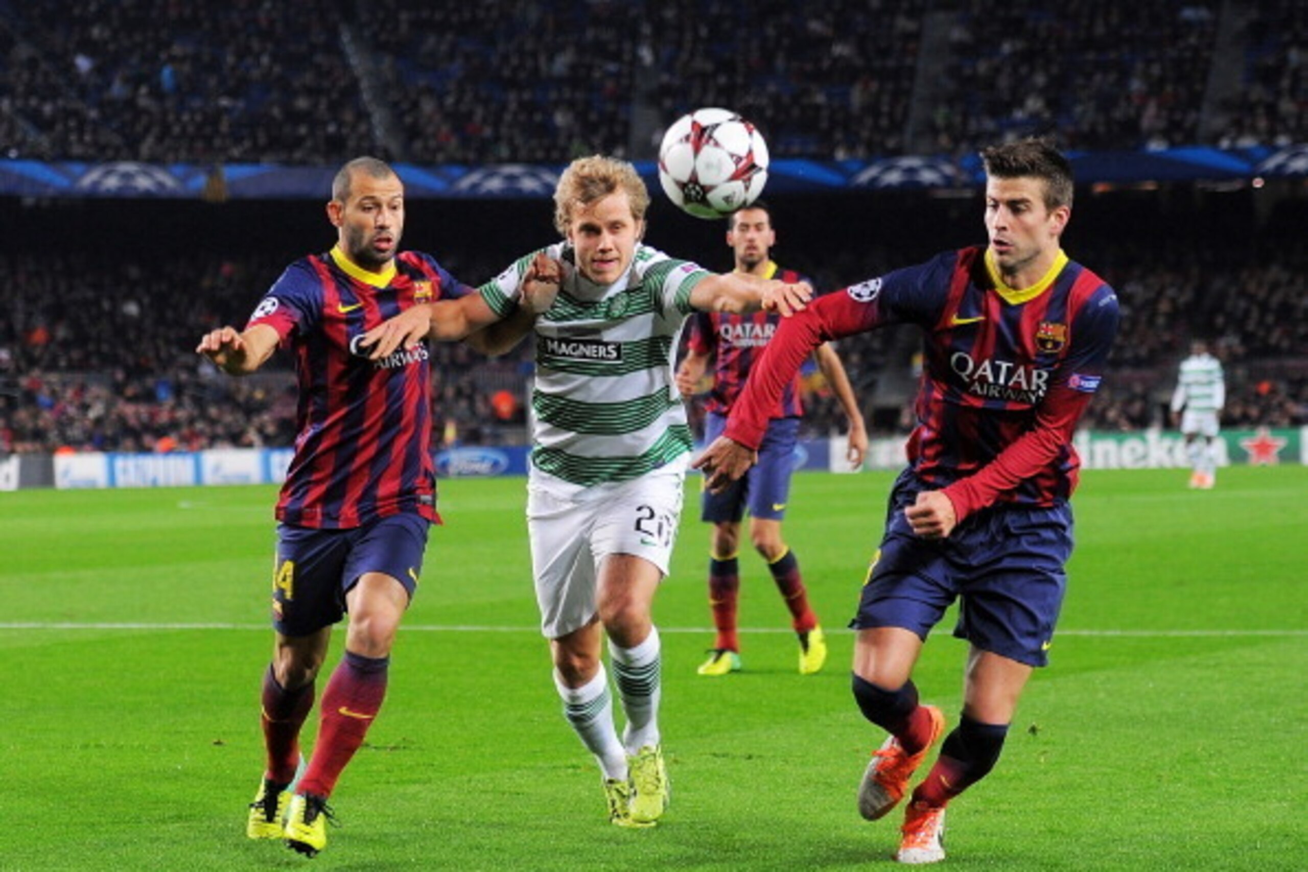 BARCELONA, SPAIN - DECEMBER 11:   Teemu Pukki (C) of Celtic FC gets between Gerard Pique (R) and Javier Mascherano of FC Barcelona battles for the ball against during the UEFA Champions League, Group H match between FC Barcelona and Celtic FC at the Camp 