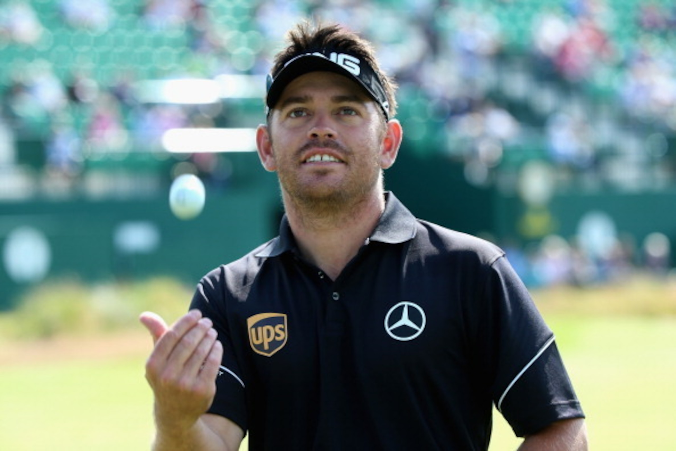 HOYLAKE, ENGLAND - JULY 15:  Louis Oosthuizen of South Africa tosses a ball to the gallery during a practice round prior to the start of The 143rd Open Championship at Royal Liverpool on July 15, 2014 in Hoylake, England.  (Photo by Andrew Redington/Getty
