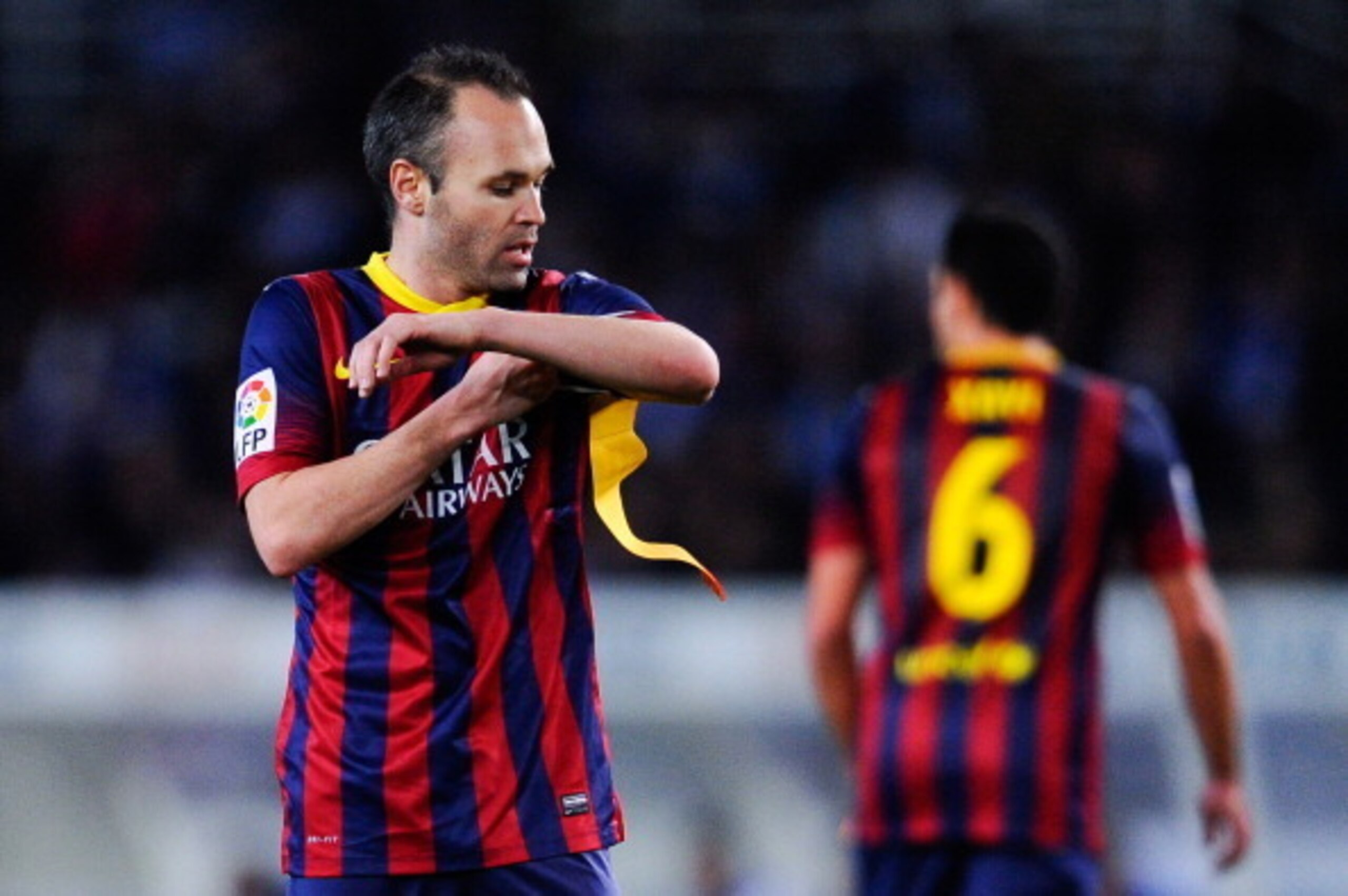 SAN SEBASTIAN, SPAIN - FEBRUARY 12: Andres Iniesta of FC Barcelona adjusts the Captain armband as his teammate Xavi Hernandez of FC Barcelona leaves the pitch during the Copa del Rey Semi Final second leg match between Real Sociedad and FC Barcelona at A SAN SEBASTIAN, SPAIN - FEBRUARY 12: Andres Iniesta of FC Barcelona adjusts the Captain armband as his teammate Xavi Hernandez of FC Barcelona leaves the pitch during the Copa del Rey Semi Final second leg match between Real Sociedad and FC Barcelona at A