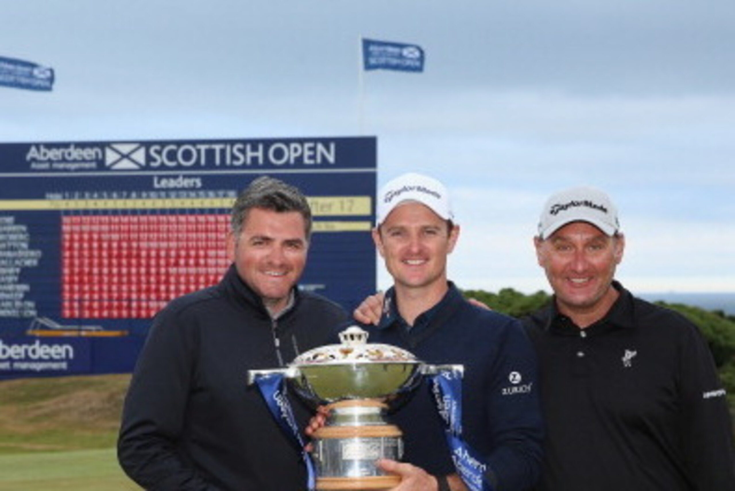 ABERDEEN, SCOTLAND - JULY 13:  Justin Rose of England (centre) celebrates on the 18th green with his friend and Management team member Paul McDonnell (left) and caddie Mark Fulcher (right) after winning the Aberdeen Asset Management Scottish Open at Royal