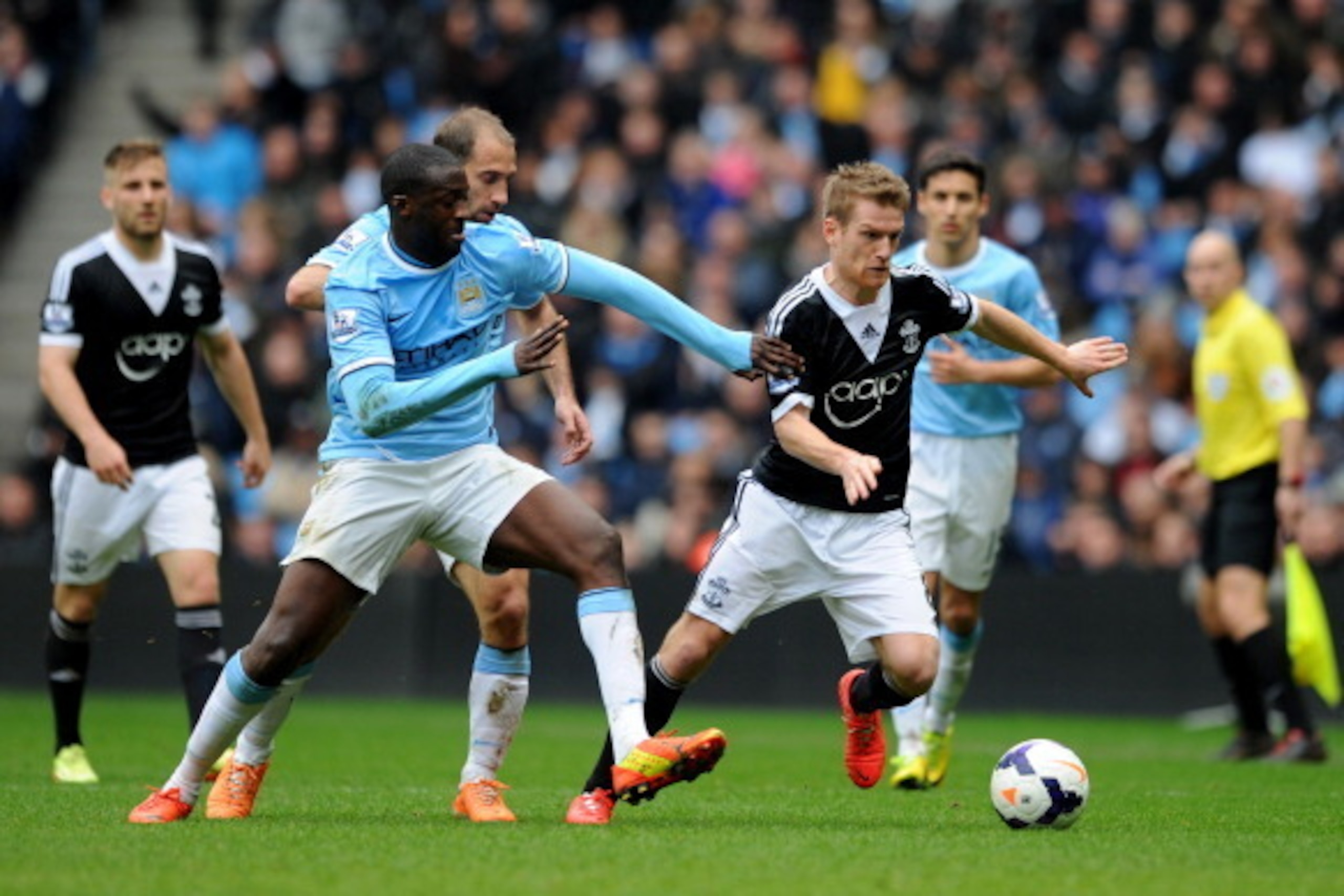 MANCHESTER, ENGLAND - APRIL 05:  Yaya Toure of Manchester City and Steven Davis of Southampton compete for the ball during the Barclays Premier League match between Manchester City and Southampton at Etihad Stadium on April 5, 2014 in Manchester, England.