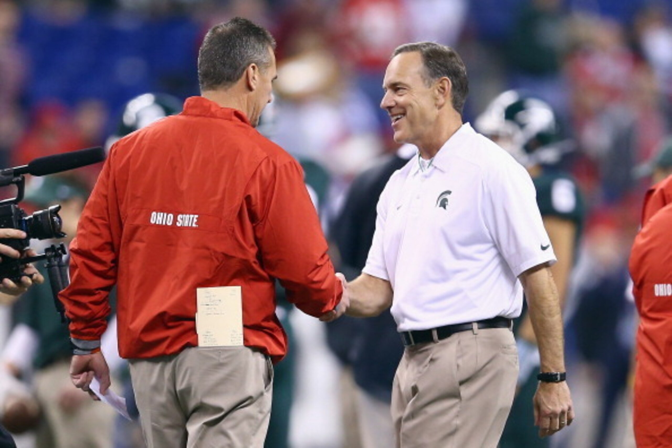 INDIANAPOLIS, IN - DECEMBER 07:  Urban Meyer the head coach of the Ohio State Buckeyes and Mark Dantonio the head coach of the Michigan State Spartans talk before the Big Ten Championship at Lucas Oil Stadium on December 7, 2013 in Indianapolis, Indiana. 