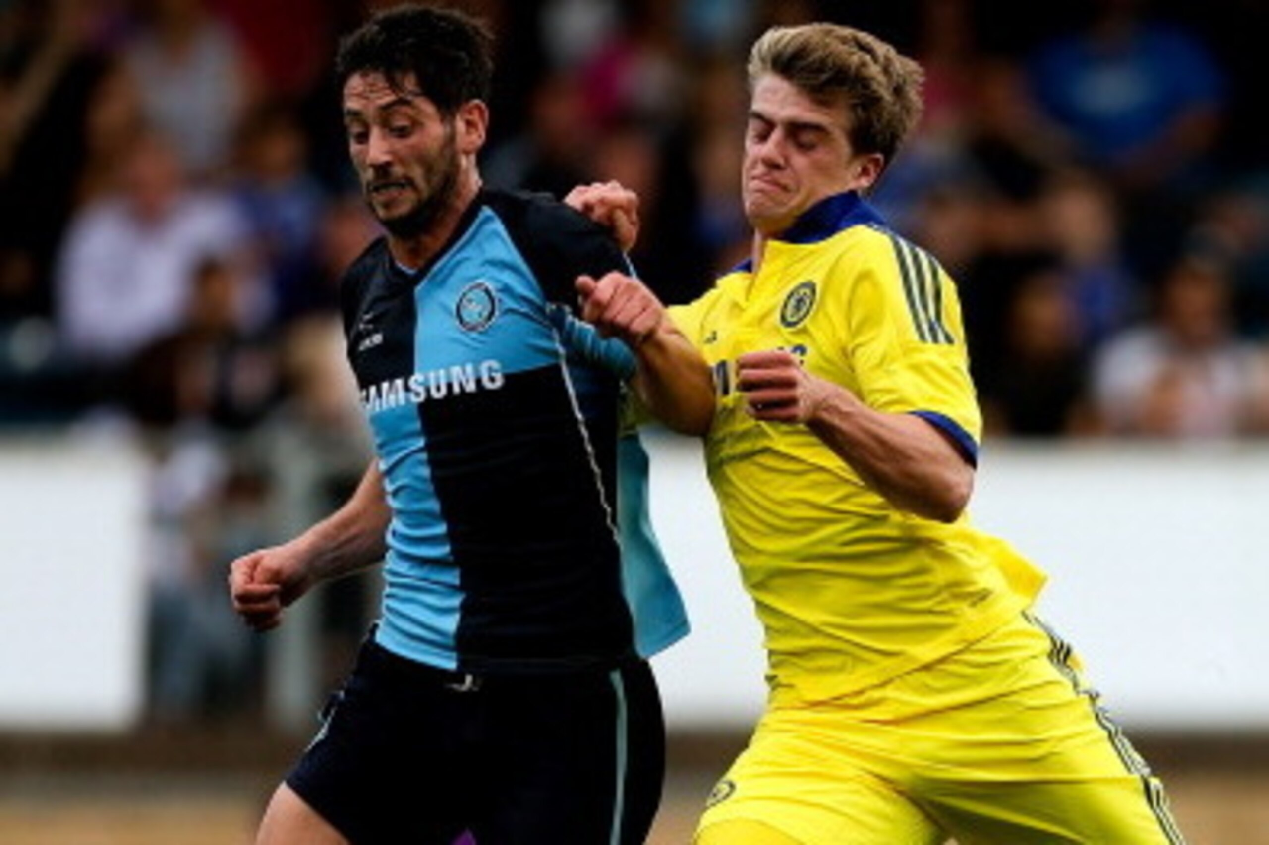 HIGH WYCOMBE, ENGLAND - JULY 16: Marco van Ginkel of Chelsea battles with Aaron Pierre of Wycombe duing the pre season friendly match between Wycombe Wanderers and Chelsea at Adams Park on July 16, 2014 in High Wycombe, England.  (Photo by Ben Hoskins/Get