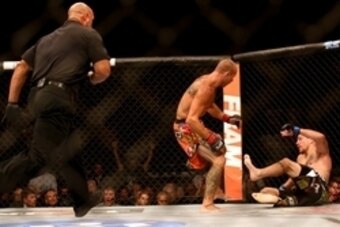 Jul 16, 2014; Atlantic City, NJ, USA; The referee comes over to break up the fight after Donald Cerrone (red gloves) knocks down Jim Miller (blue gloves) during a 5-round lightweight bout at Revel Casino. Mandatory Credit: Bill Streicher-USA TODAY Sports