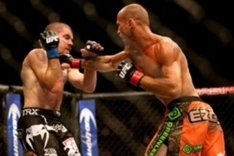 Jul 16, 2014; Atlantic City, NJ, USA; Donald Cerrone (red gloves) takes a punch from Jim Miller (blue gloves) during a 5-round lightweight bout at Revel Casino. Mandatory Credit: Bill Streicher-USA TODAY Sports