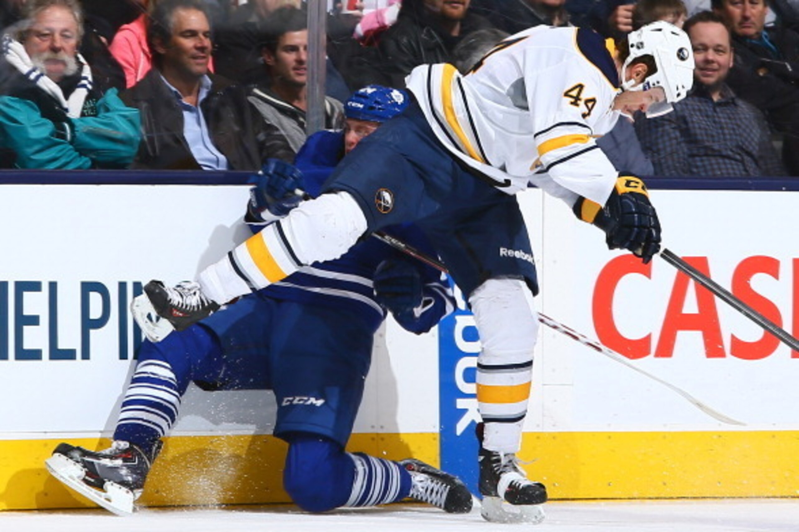 TORONTO , ON - JANUARY 15: Peter Holland #24 of the Toronto Maple Leafs gets hit by Brayden McNabb #44 of the Buffalo Sabres during NHL game action January 15, 2014 at the Air Canada Centre in Toronto, Ontario, Canada. (Photo by Graig Abel/NHLI via Getty 