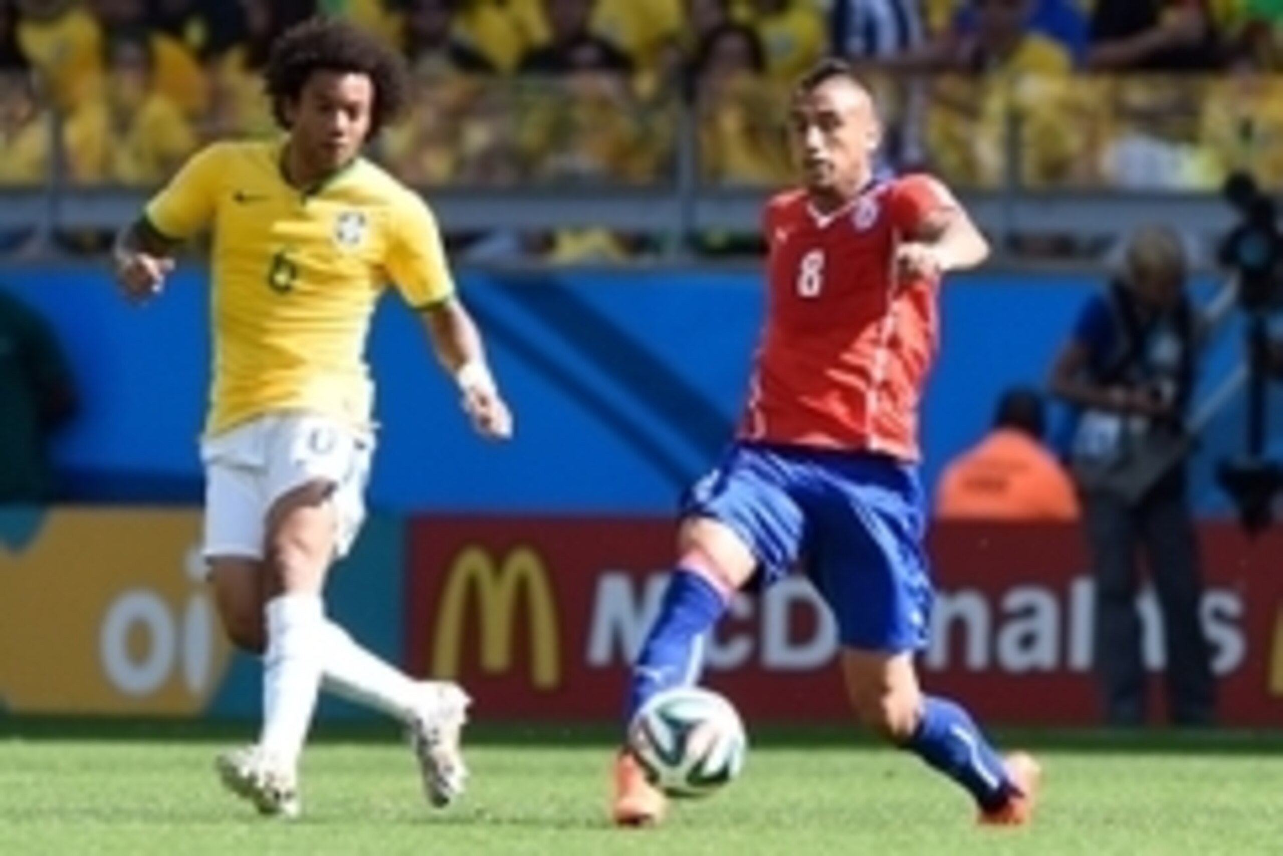 June 28, 2014; Belo Horizonte, BRAZIL; Brazil player Marcelo (left) chases the ball with Chile player Arturo Vidal  during the round of sixteen match in the 2014 World Cup at Estadio Mineirao.  Mandatory Credit: Tim Groothuis/Witters Sport via USA TODAY S