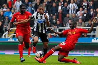 NEWCASTLE-UPON-TYNE, ENGLAND - OCTOBER 19: Loic Remy (C) of Newcastle in action with Kolo Toure (L) and Aly Cissokho of Liverpool during the Barclays Premier League match between Newcastle United and Liverpool at St James' Park on October 19, 2013 in Newc