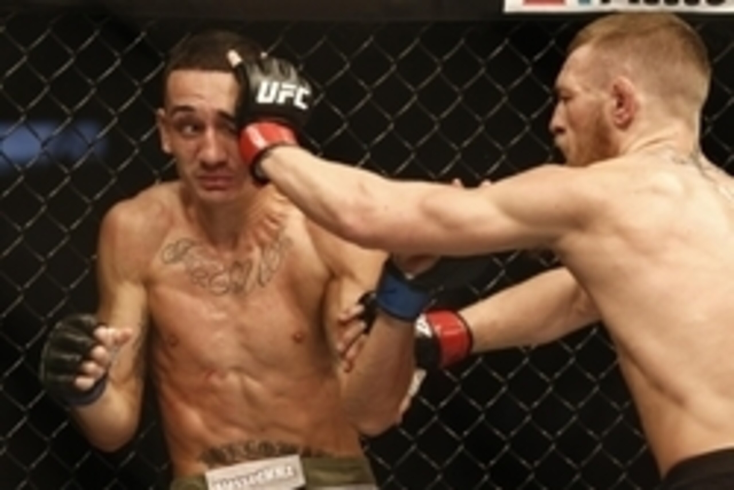 Aug 17, 2013; Boston, MA, USA; Conor McGregor (black shorts) and Max Holloway (white shorts) fight  during a UFC featherweight match at the TD Garden. McGregor won after three rounds by judges decision. Mandatory Credit: Winslow Townson-USA TODAY Sports