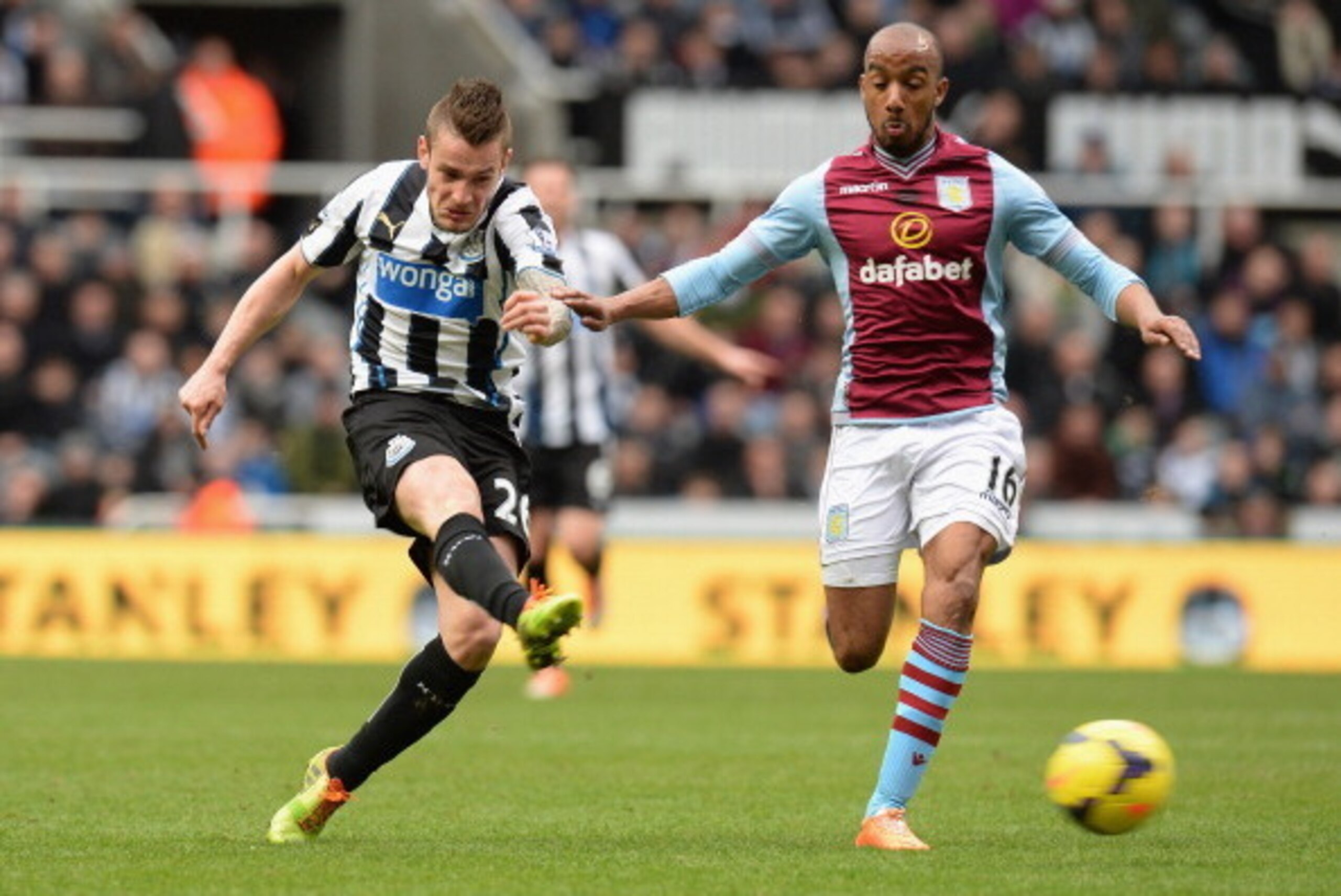 NEWCASTLE UPON TYNE, ENGLAND - FEBRUARY 23:  Mathieu Debuchy of Newcastle United takes a shot at goal past Fabian Delph of Aston Villa during the Barclays Premier League match between Newcastle United and Aston Villa at St James' Park on February 23, 2014