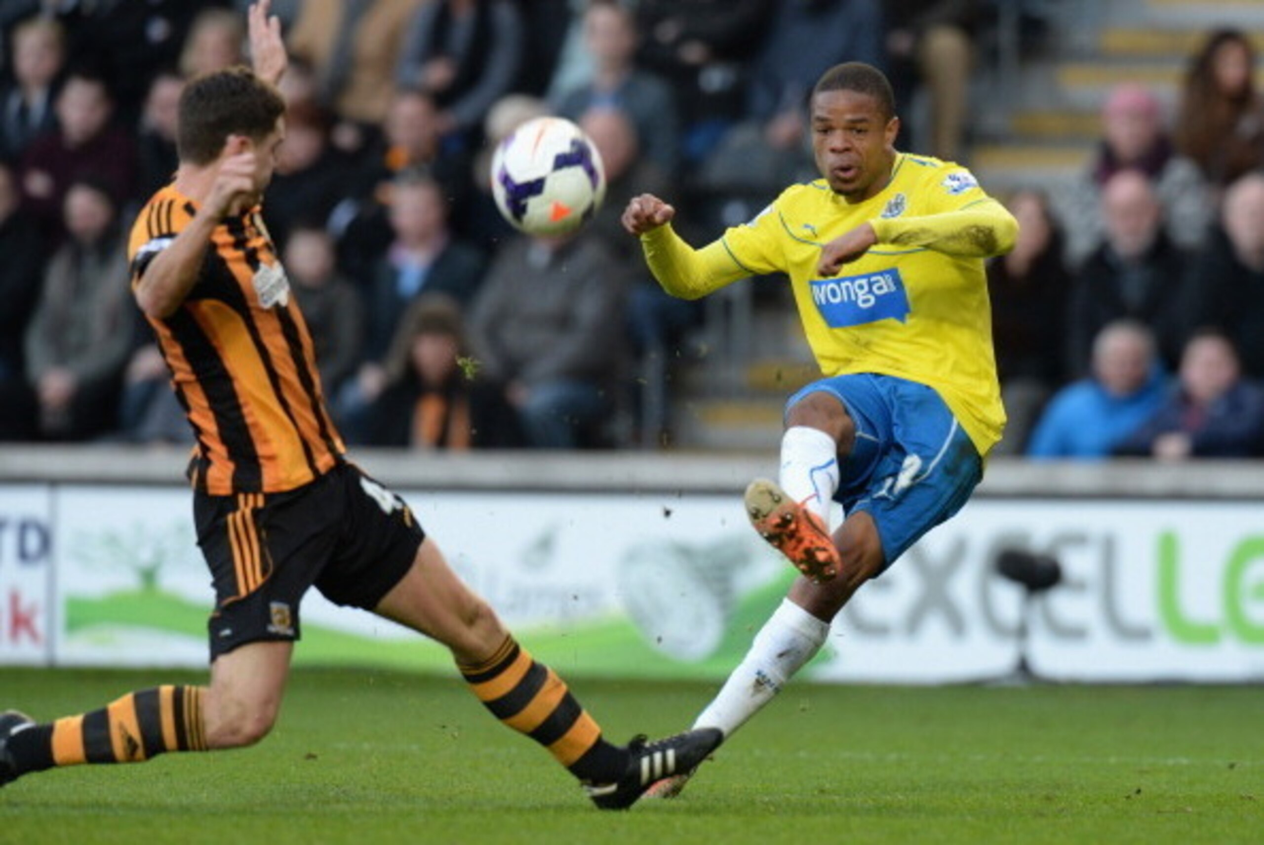 HULL, ENGLAND - MARCH 01: Loic Remy of Newcastle United shoots past Alex Bruce of Hull City during the Barclays Premier League match between Hull City and Newcastle United at KC Stadium on March 1, 2014 in Hull, England.  (Photo by Tony Marshall/Getty Ima