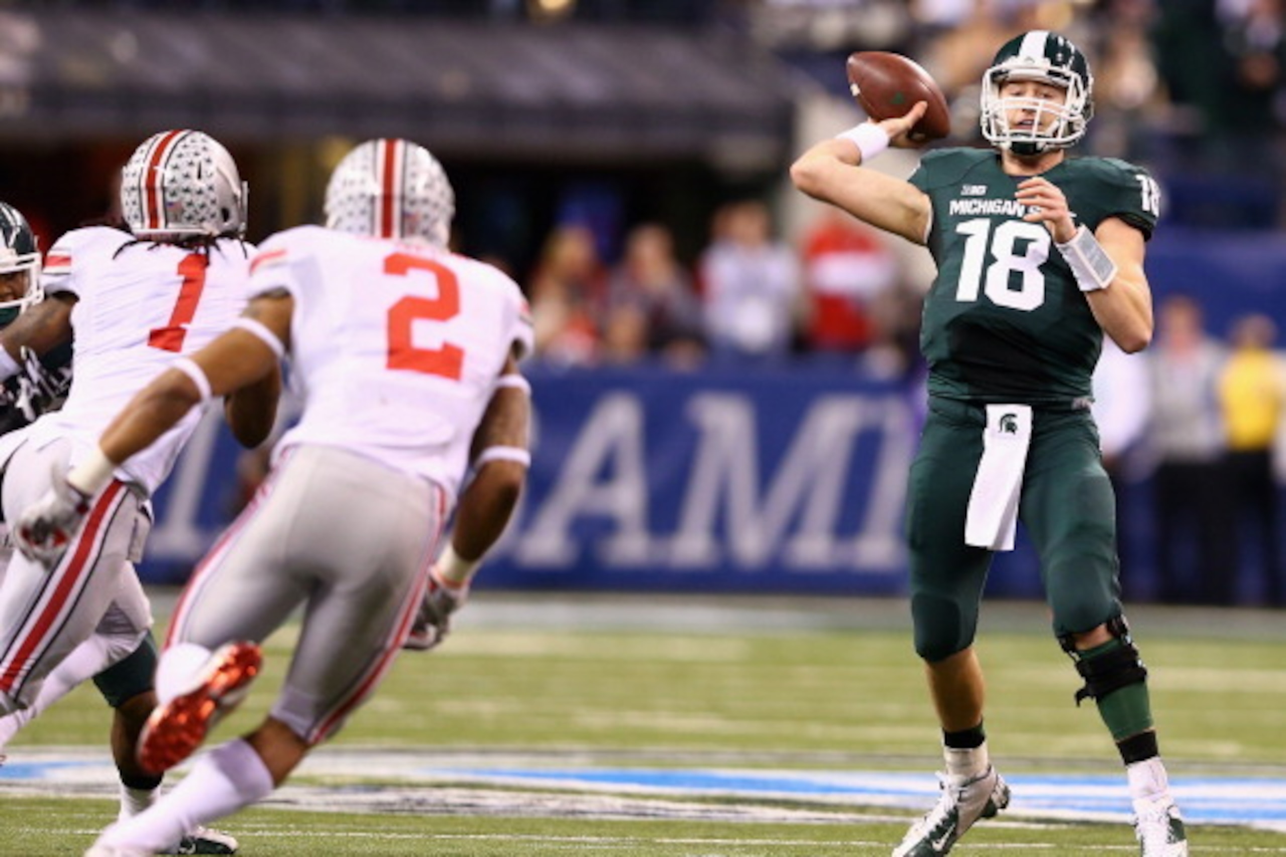 INDIANAPOLIS, IN - DECEMBER 07:  Quarterback Connor Cook #18 of the Michigan State Spartans throws a touchdown pass against the Ohio State Buckeyes during the Big Ten Conference Championship game at Lucas Oil Stadium on December 7, 2013 in Indianapolis, I