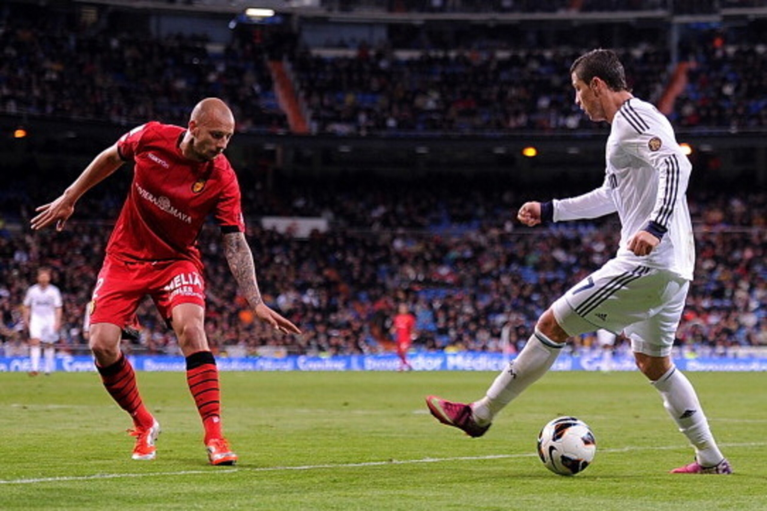 MADRID, SPAIN - MARCH 16:  Cristiano Ronaldo (R) of Real Madrid CF takes on Alan Hutton of RCD Mallorca during the La Liga match between Real Madrid CF and RCD Mallorca at estadio Santiago Bernabeu on March 16, 2013 in Madrid, Spain.  (Photo by Denis Doyl
