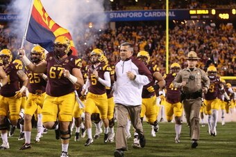 TEMPE, AZ - DECEMBER 07:  Head coach Todd Graham of the Arizona State Sun Devils runs out with teammates before the Pac 12 Championship game against the Stanford Cardinal at Sun Devil Stadium on December 7, 2013 in Tempe, Arizona. The Carindal defeated th