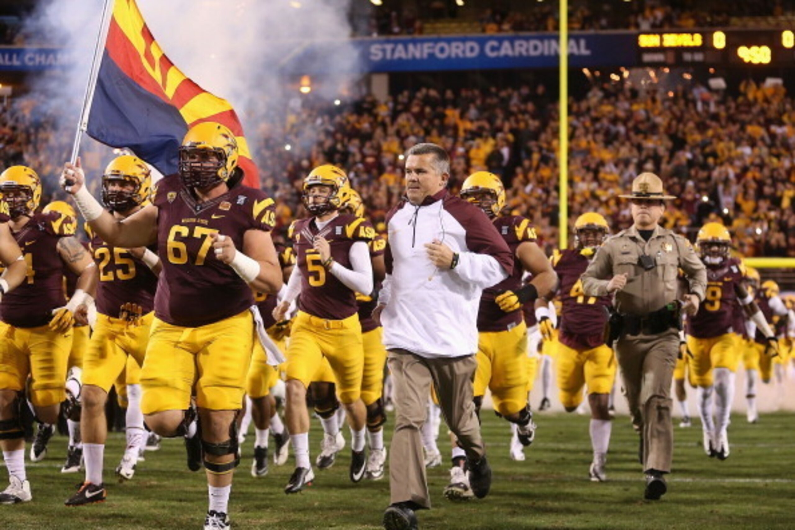 TEMPE, AZ - DECEMBER 07:  Head coach Todd Graham of the Arizona State Sun Devils runs out with teammates before the Pac 12 Championship game against the Stanford Cardinal at Sun Devil Stadium on December 7, 2013 in Tempe, Arizona. The Carindal defeated th