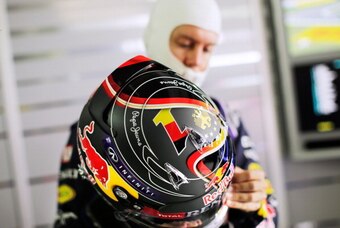 HOCKENHEIM, GERMANY - JULY 18:  Sebastian Vettel of Germany and Infiniti Red Bull Racing holds his race helmet, which has been customised in celebration of the German national football team's World Cup victory, as he prepares in the garage during practice