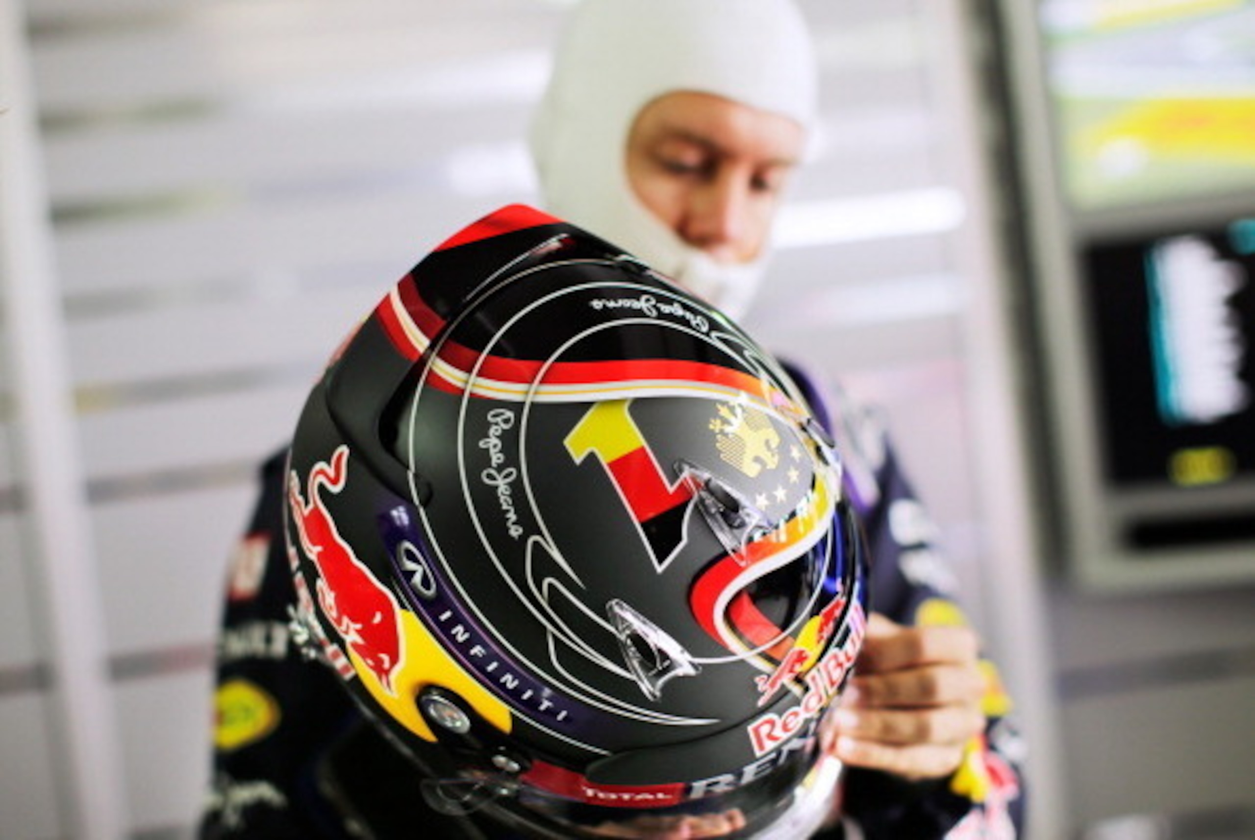 HOCKENHEIM, GERMANY - JULY 18: Sebastian Vettel of Germany and Infiniti Red Bull Racing holds his race helmet, which has been customised in celebration of the German national football team's World Cup victory, as he prepares in the garage during practice HOCKENHEIM, GERMANY - JULY 18: Sebastian Vettel of Germany and Infiniti Red Bull Racing holds his race helmet, which has been customised in celebration of the German national football team's World Cup victory, as he prepares in the garage during practice