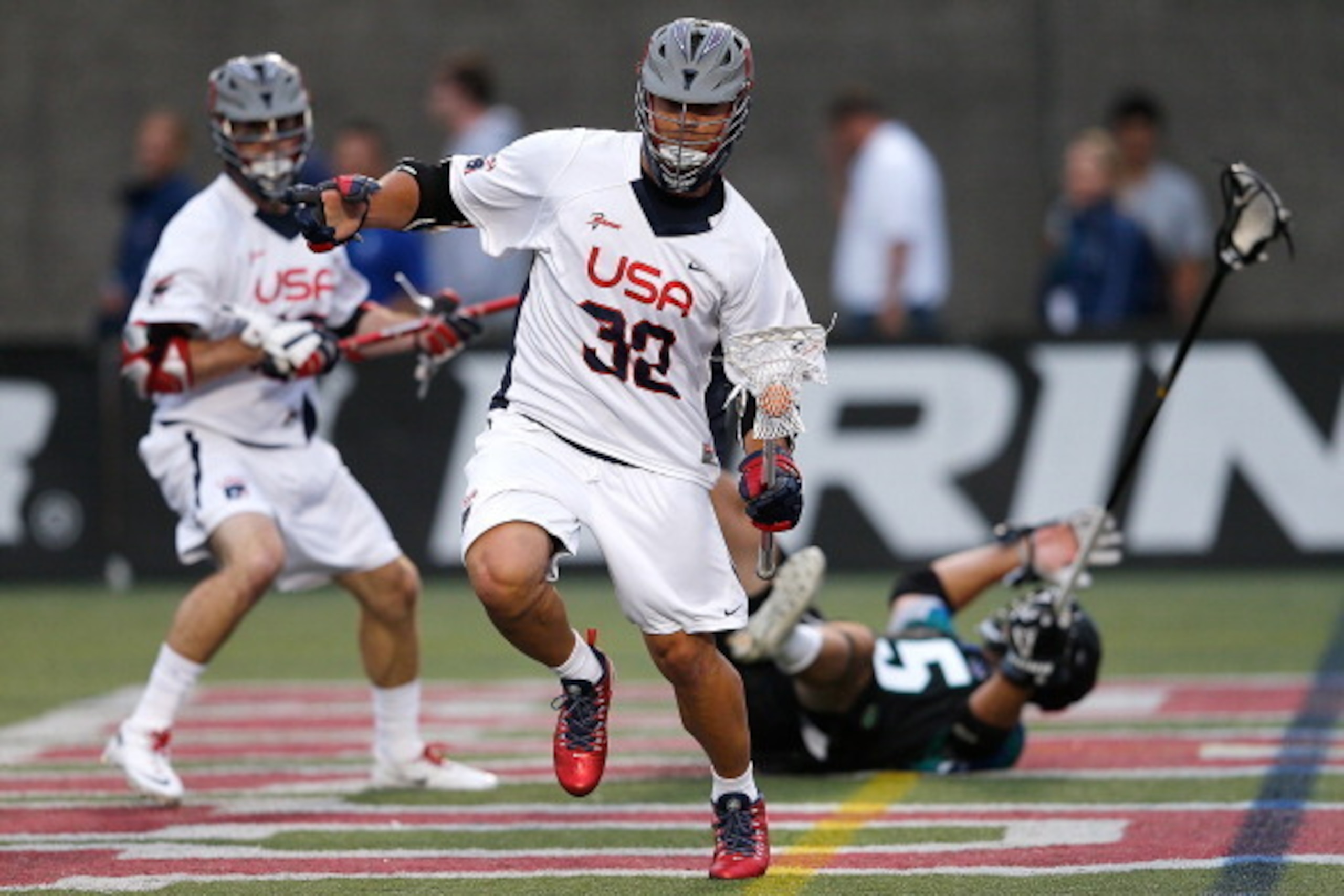 BOSTON, MA - JUNE 26: Rob Pannell #32 of Team USA gets by Jordan Burke #5 of Team MLL in the first quarter during the 2014 MLL All Star Game at Harvard Stadium on June 26, 2014 in Boston, Massachusetts.  (Photo by Jim Rogash/Getty Images)