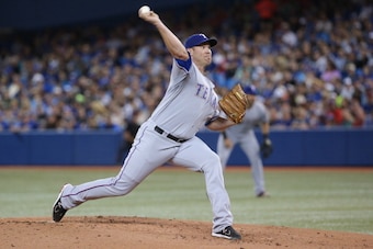 TORONTO, CANADA - JULY 19: Colby Lewis #48 of the Texas Rangers delivers a pitch in the first inning during MLB game action against the Toronto Blue Jays on July 19, 2014 at Rogers Centre in Toronto, Ontario, Canada. (Photo by Tom Szczerbowski/Getty Image