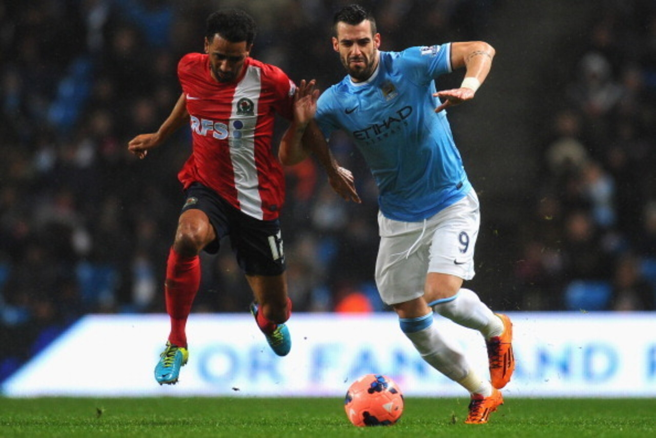 MANCHESTER, ENGLAND - JANUARY 15:  Alvaro Negredo of Manchester City is challenged by Lee Williamson of Blackburn Rovers during the Budweiser FA Cup Third Round Replay match between Manchester City and Blackburn Rovers at the Etihad Stadium on January 15,
