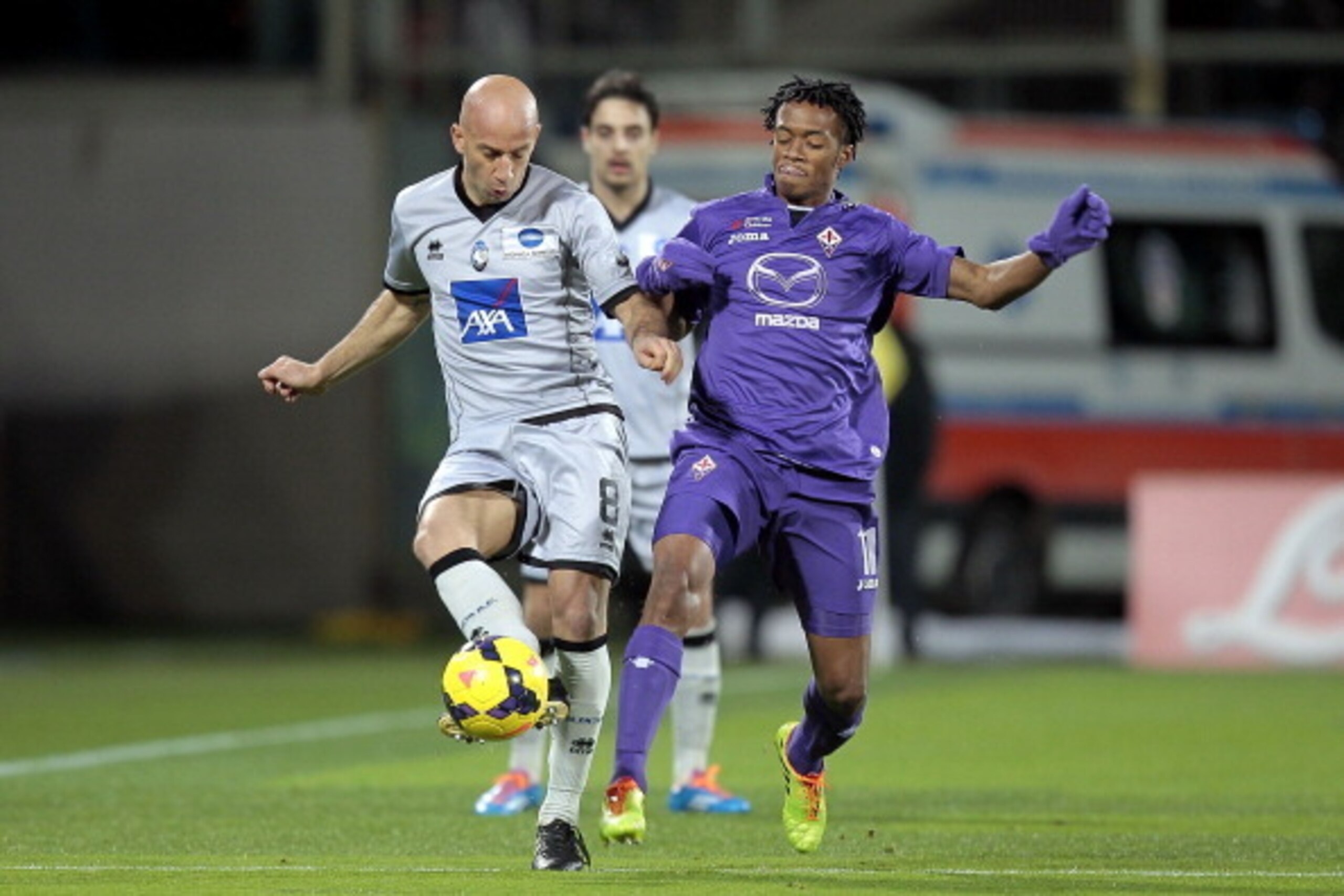 FLORENCE, ITALY - FEBRUARY 08: Guillermo Cuadrado (R) of ACF Fiorentina fights for the ball with Giulio Migliaccio of Atalanta BC during the Serie A match between ACF Fiorentina and Atalanta BC at Stadio Artemio Franchi on February 8, 2014 in Florence, It
