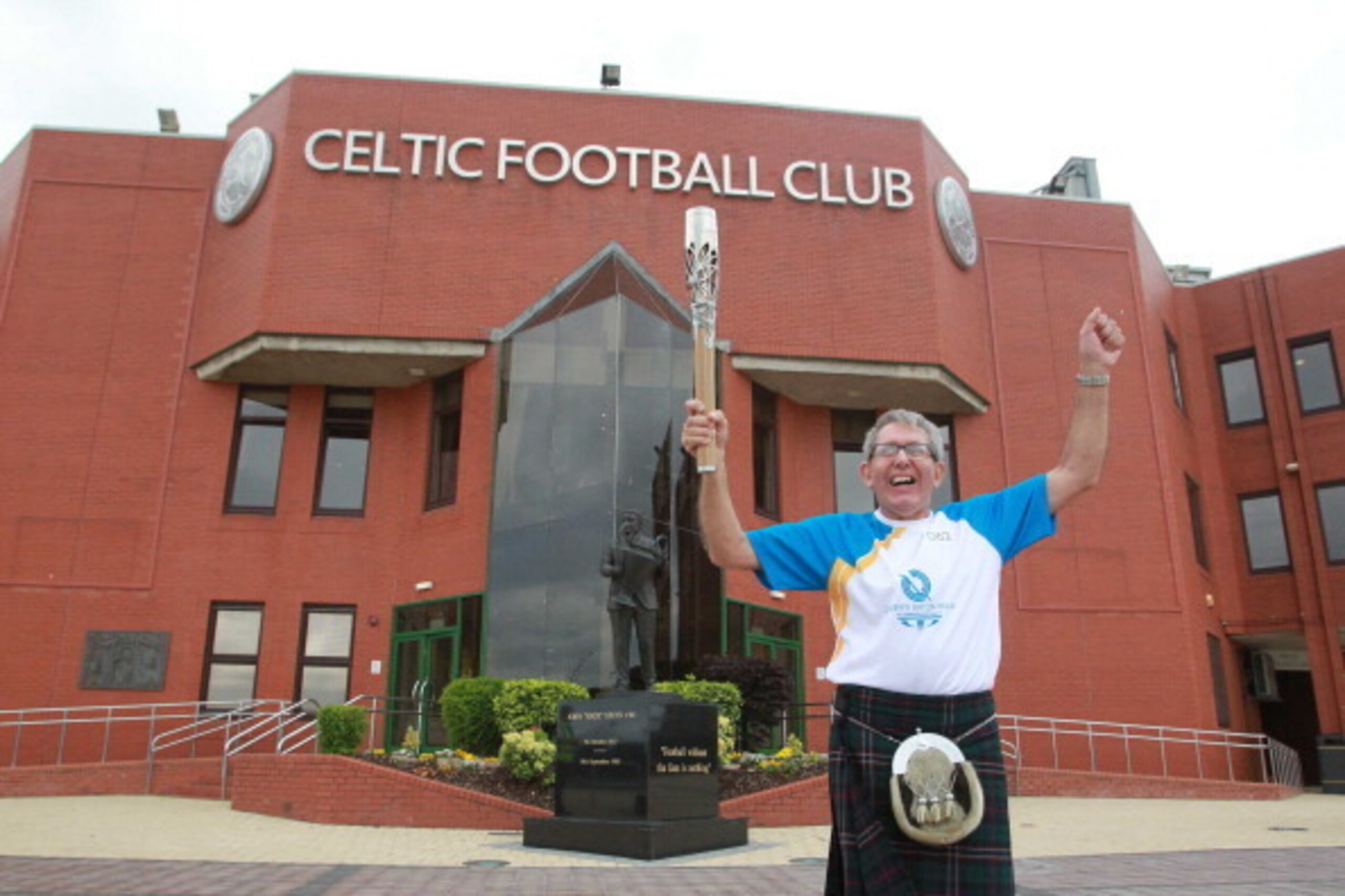 GLASGOW, SCOTLAND - JULY 20: Batonbearer 062 John Zambonini carries the Glasgow 2014 Queen's Baton at Celtic Park, home of Celtic Football Club on July 20, 2014 in Glasgow, Scotland. Scotland is nation 70 of 70 nations and territories the Queen's Baton wi