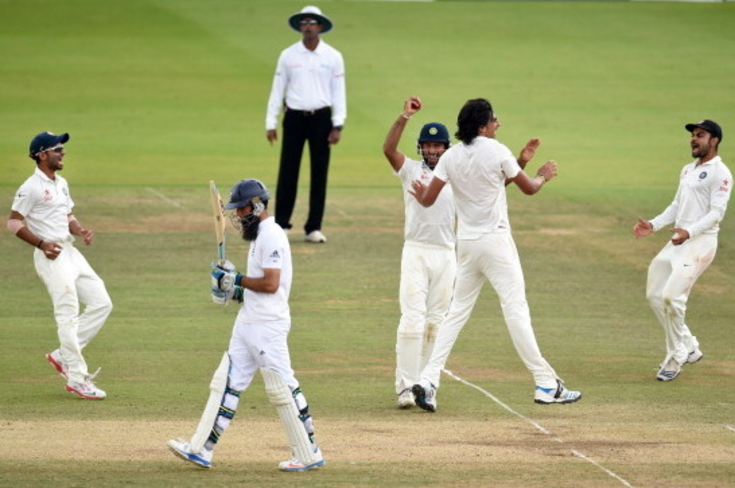 LONDON, ENGLAND - JULY 21:  England batsman Moeen Ali walks off after being caught by India fielder Cheteshwar Pujara (c) off bowler Ishant Sharma (2nd r) during day five of 2nd Investec Test match between England and India at Lord's Cricket Ground on Jul