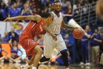 Mar 5, 2014; Lawrence, KS, USA; Kansas Jayhawks guard Naadir Tharpe (10) moves the ball against Texas Tech Red Raiders guard Robert Turner (14) in the second half at Allen Fieldhouse. Kansas won the game 82-57. Mandatory Credit: John Rieger-USA TODAY Spor